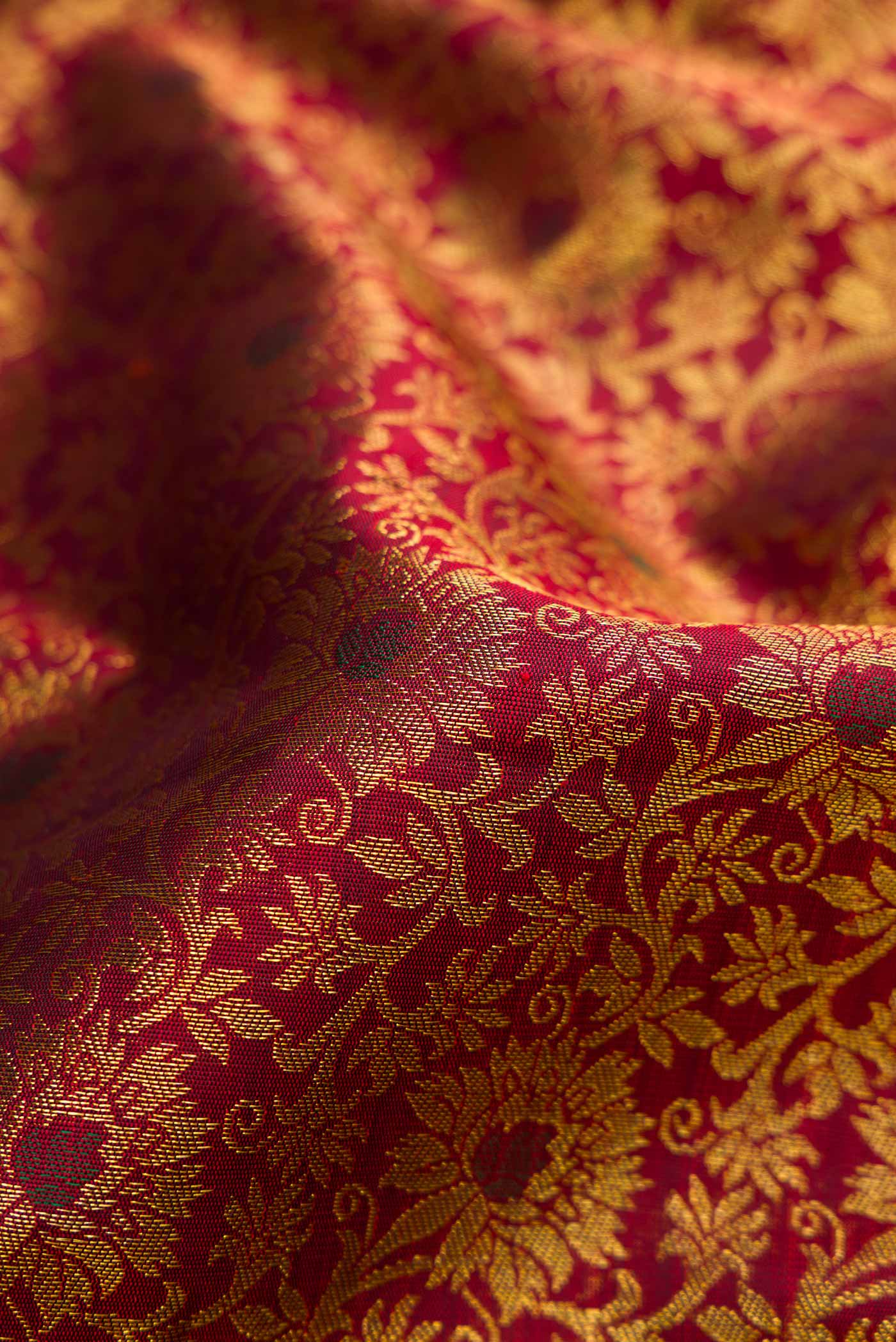 Close up of Pure Silk Pure Zari Maroon Dual Tone Kanchipuram Saree with Zari Brocade on the body and Zari Border displaying folds