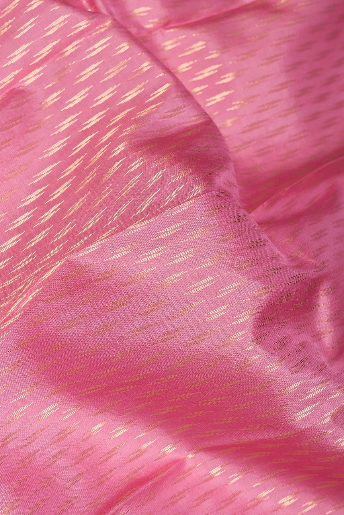 Close up of Pink Dual Tone Kanchipuram Silk Saree with Zari Butta on the body and Zari Border.  displaying folds