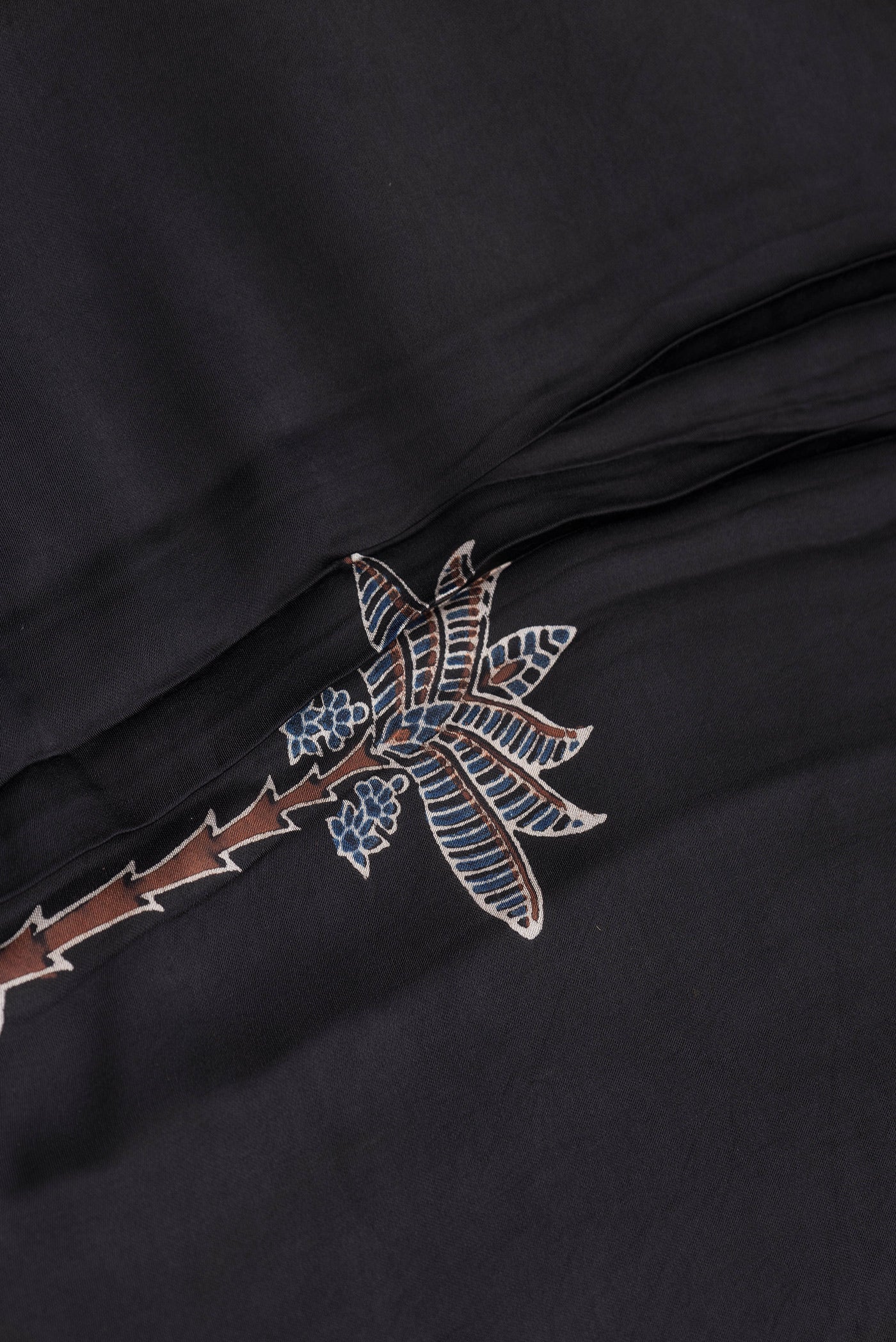 Close up of Black Dual Tone Blended Crepe Saree with Ajrakh Print on the body and Printed Border.  displaying folds