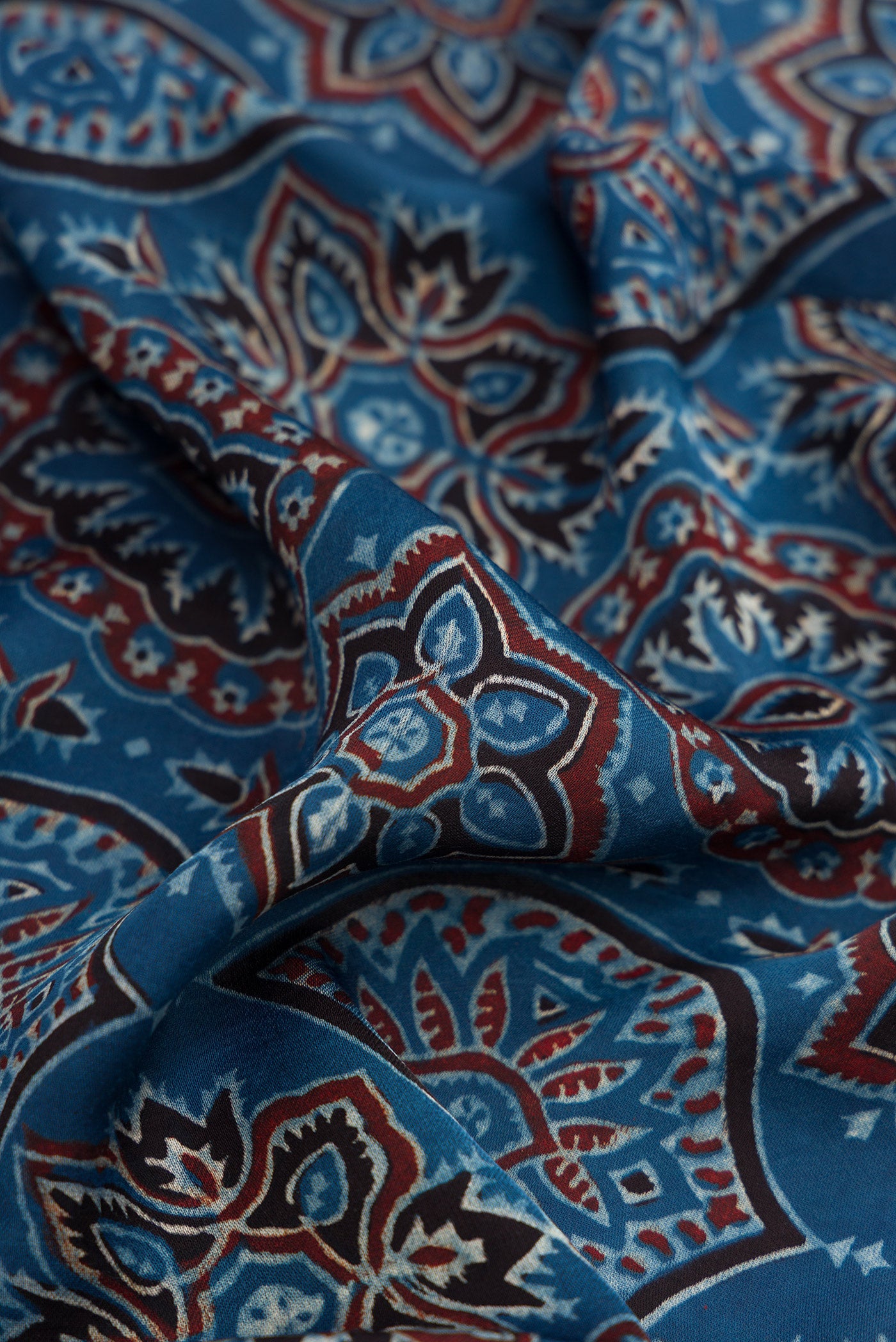 Close up of Navy Blue Dual Tone Crepe Saree with Ajrakh Print on the body and Printed Border.  displaying folds
