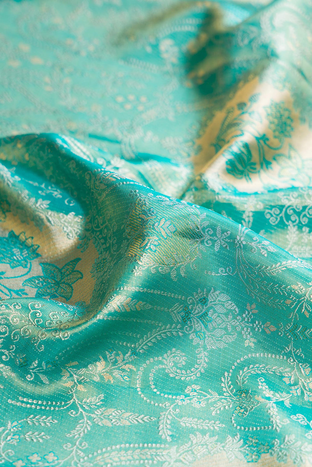 Close up of Turquoise Dual Tone Kanchipuram Tissue Silk Saree with Zari Brocade on the body and Zari Border.  displaying folds
