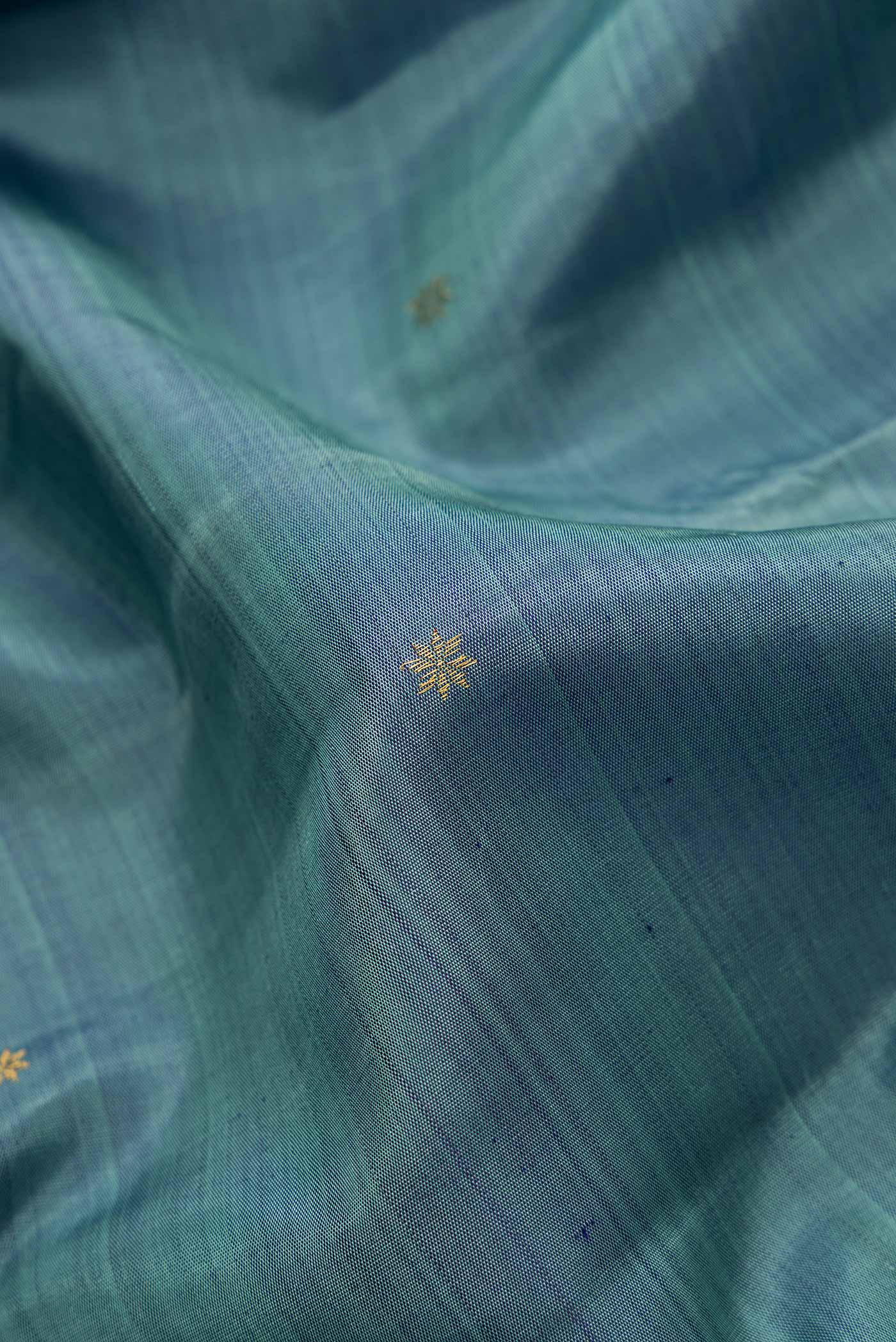 Close up of Pure Silk Pure Zari Maya Blue Dual Tone Kanjivaram Saree with Zari Butta on the body and Fancy Border.  displaying folds