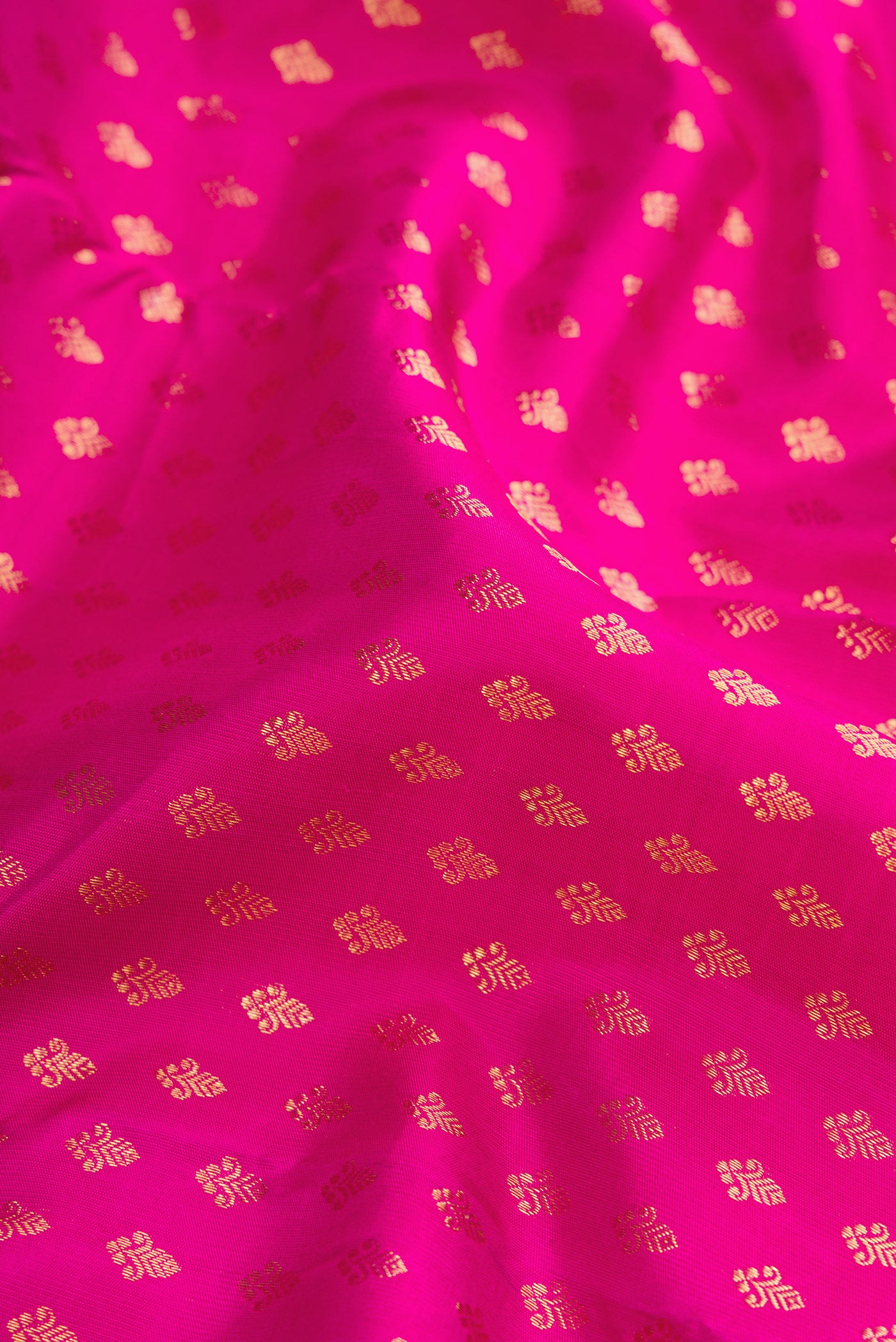 Close up of Pure Silk Pure Zari Pink Dual Tone Kanjivaram Saree with Zari Butta on the body and Zari Border.  displaying folds