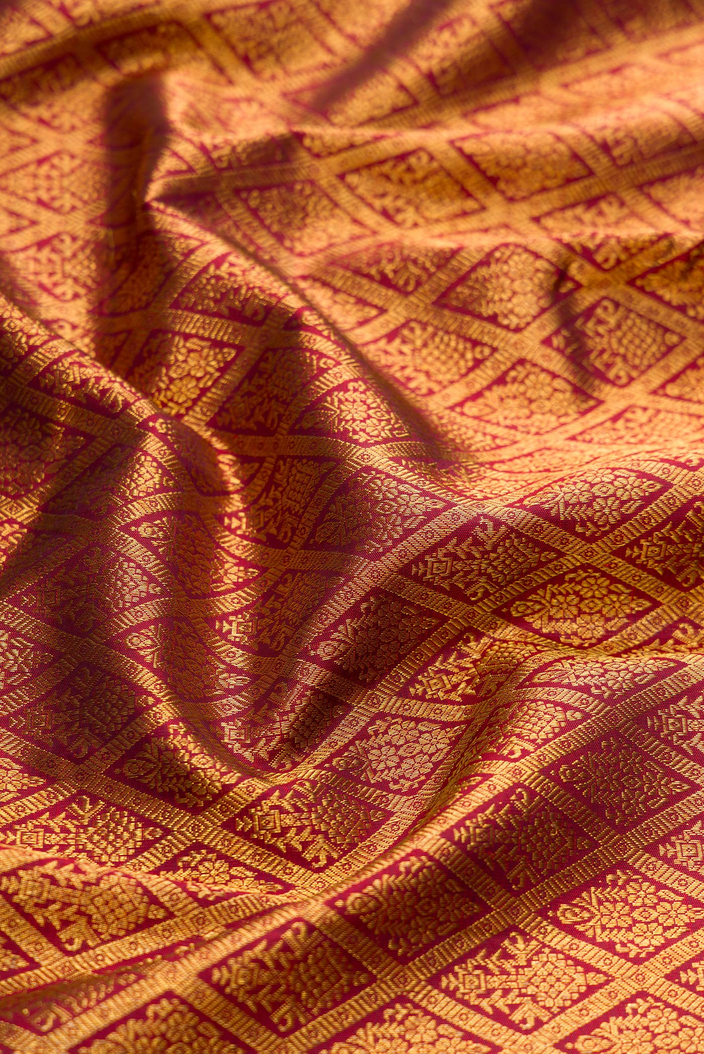 Close up of Maroon Dual Tone Kanchipuram Silk Saree with Zari Brocade on the body and Zari Border.  displaying folds