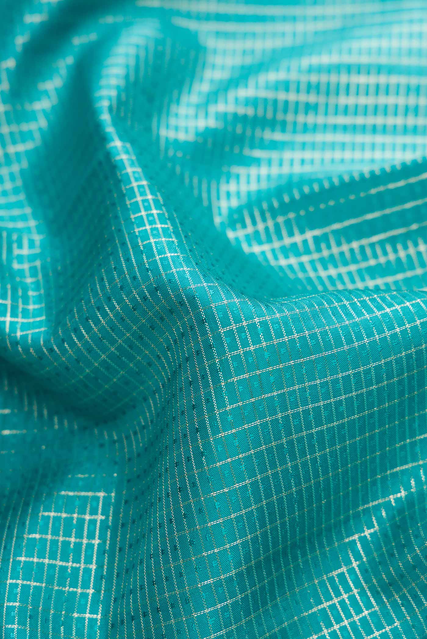 Close up of Sky Blue Dual Tone Kanchipuram Silk Saree with Zari Brocade on the body and Zari Border.  displaying folds