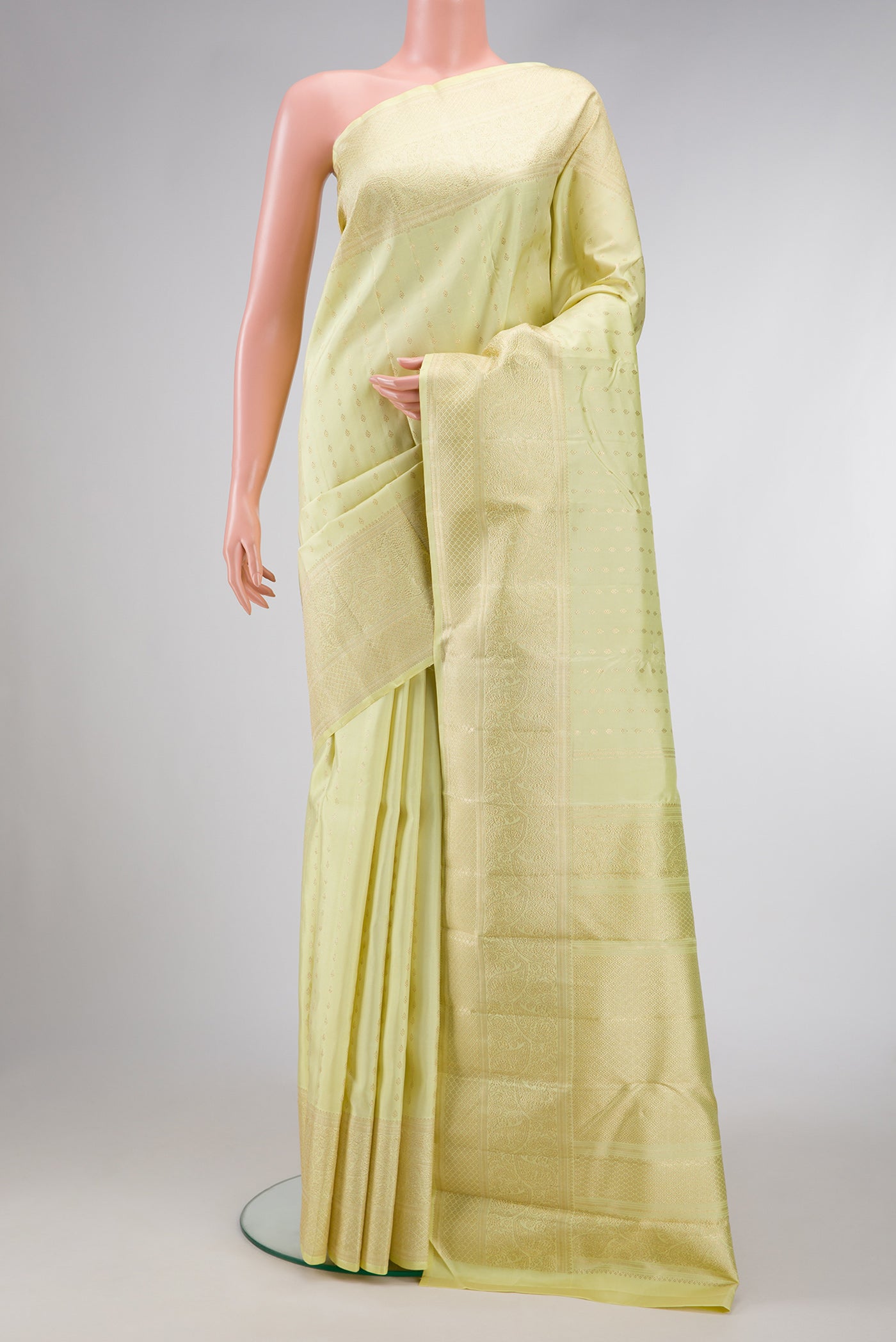 Pista Green Dual Tone Kanchipuram Silk Saree with Zari Butta on the body and Zari Border.  displayed on a mannequin