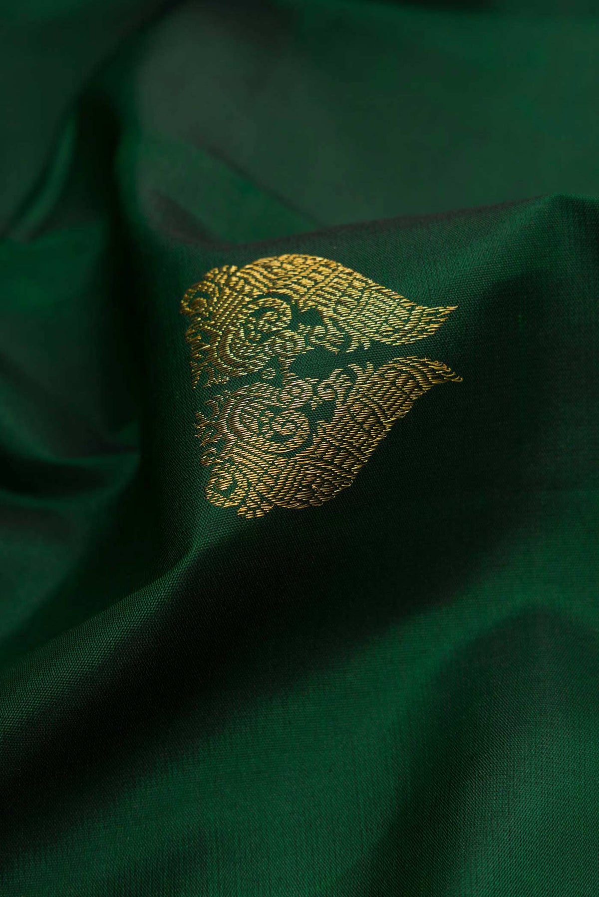 Close up of Green Dual Tone Kanchipuram Silk Saree with Zari Butta on the body and Zari Border displaying folds