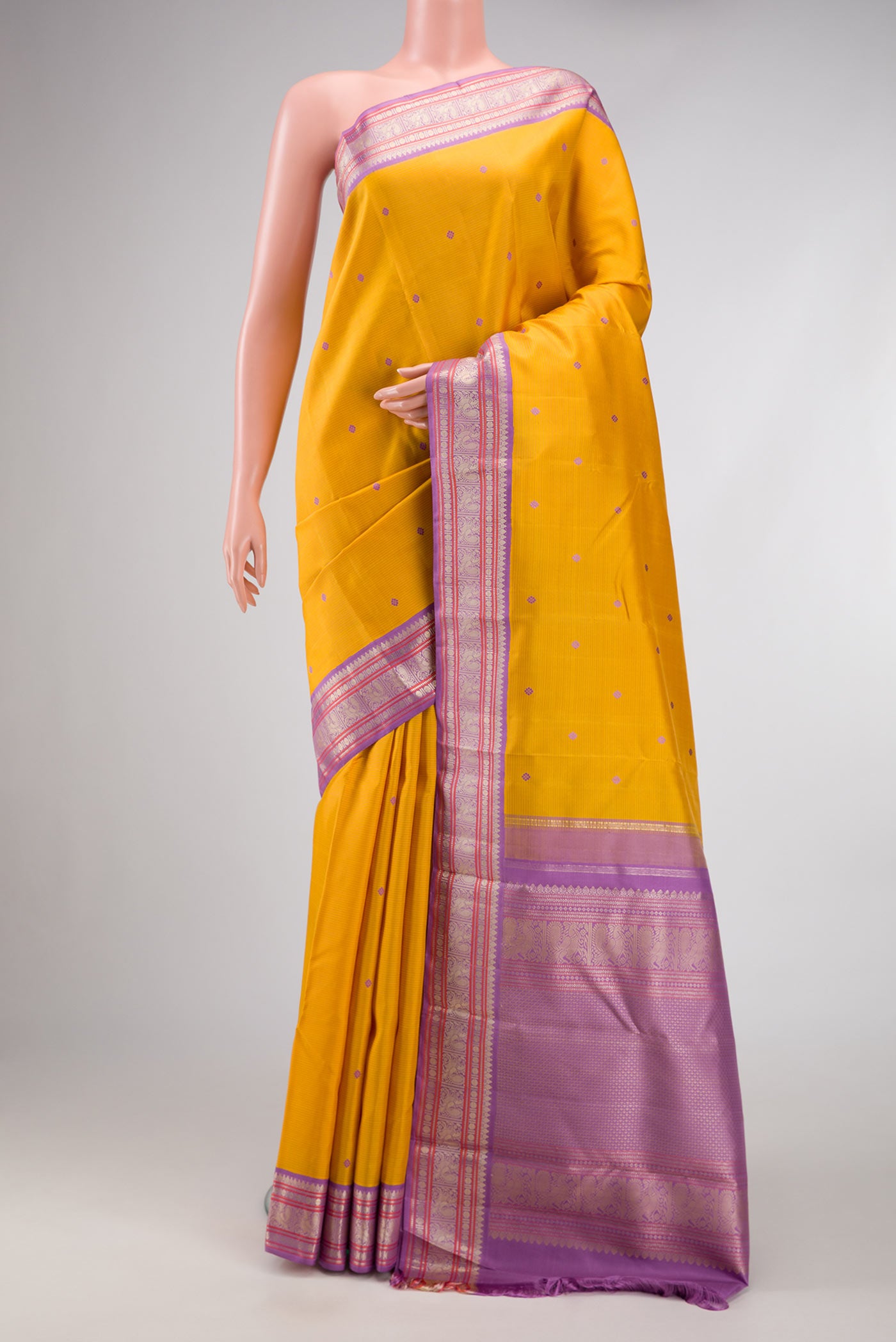 Pure Silk Pure Zari Mustard Dual Tone Kanchipuram Saree with Thread Butta on the body and Zari Border.  displayed on a mannequin