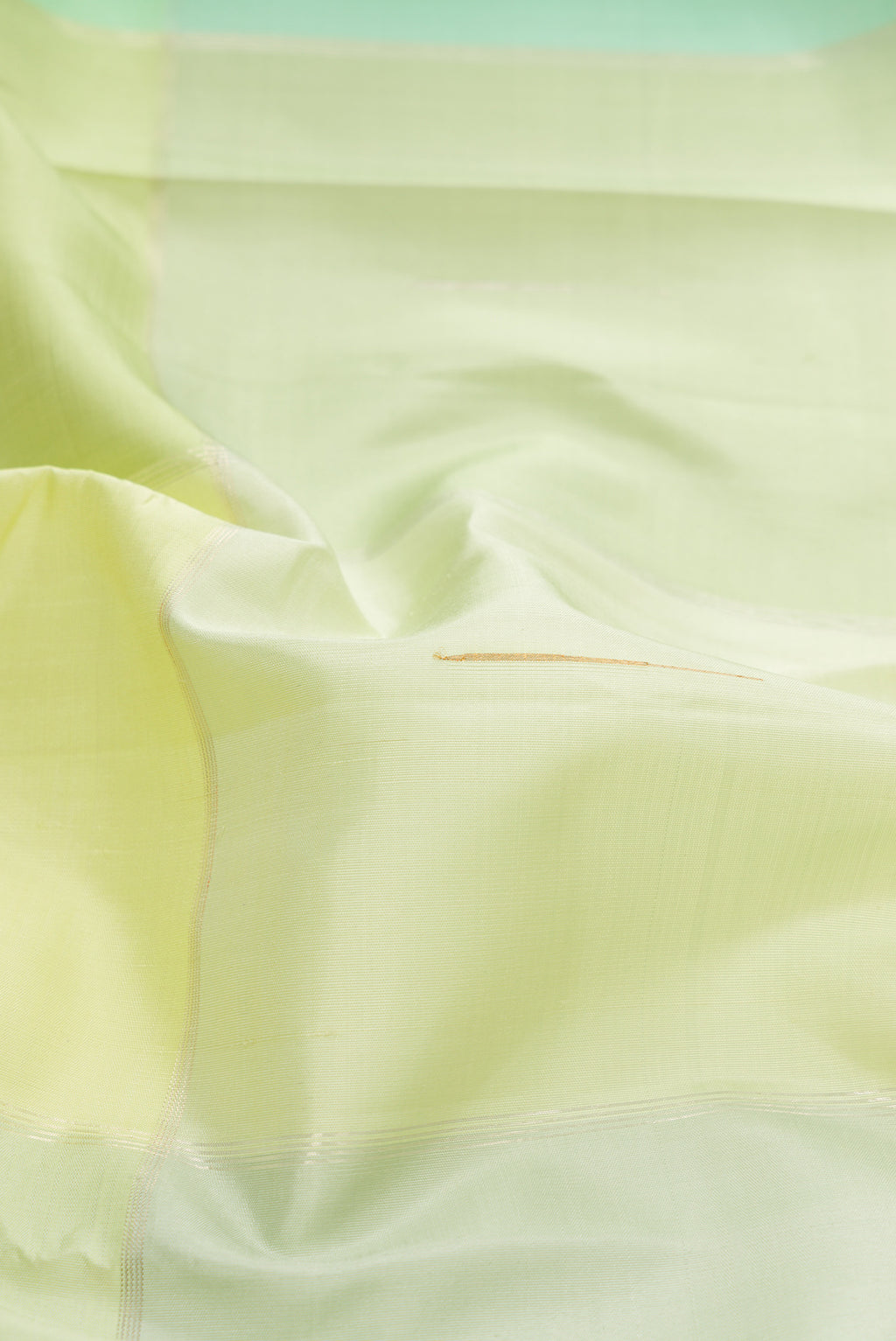 Close up of Light Green and Sea Green Color Kanchipuram Silk Saree with Checked design on the body and Zari Border.  displaying folds