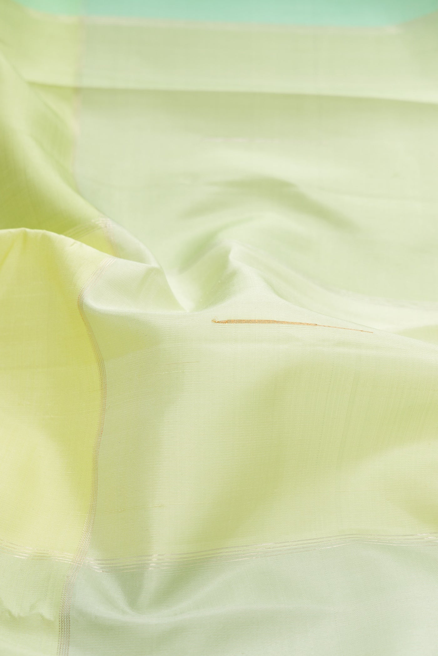 Close up of Light Green and Sea Green Color Kanchipuram Silk Saree with Checked design on the body and Zari Border.  displaying folds