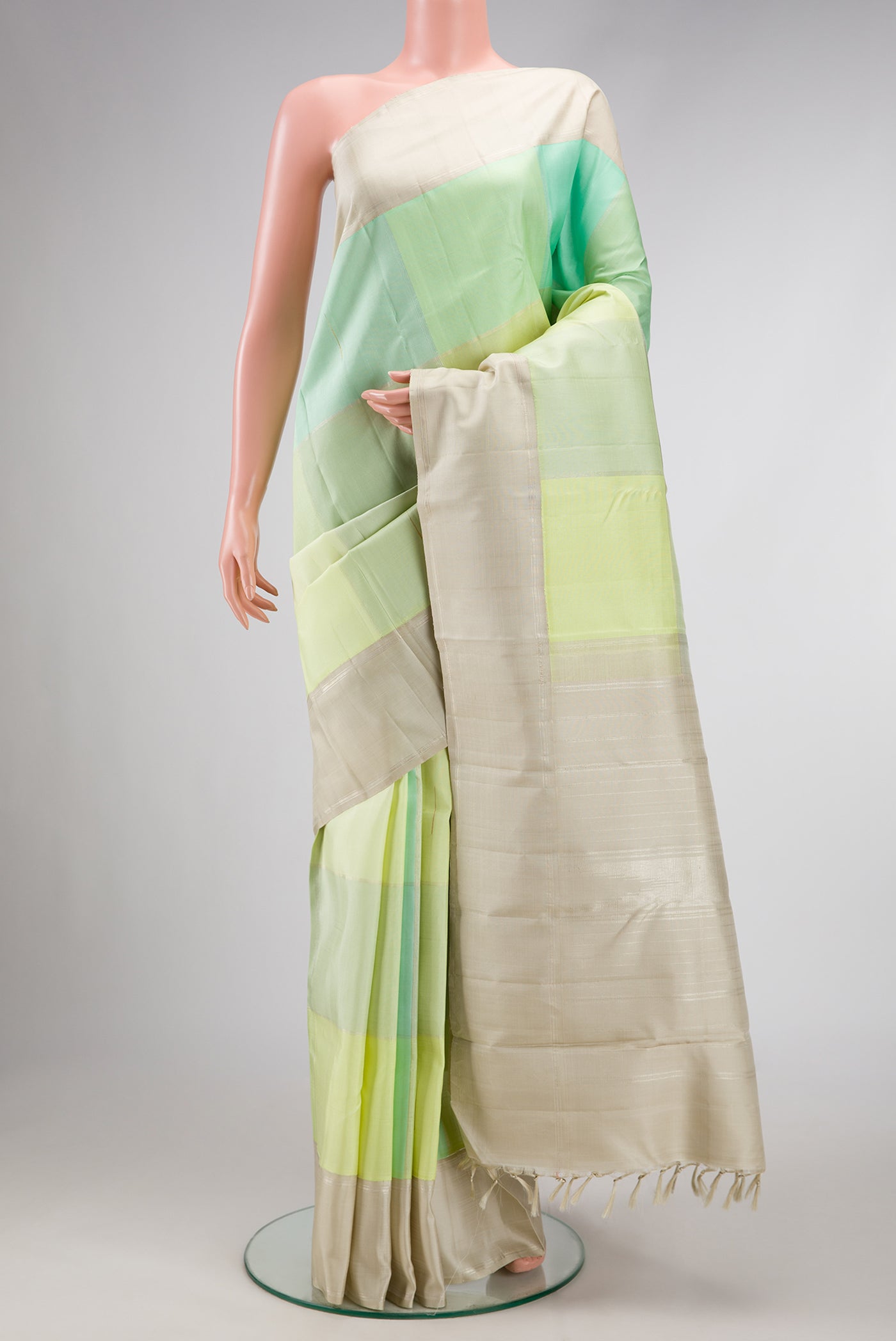 Light Green and Sea Green Color Kanchipuram Silk Saree with Checked design on the body and Zari Border.  displayed on a mannequin
