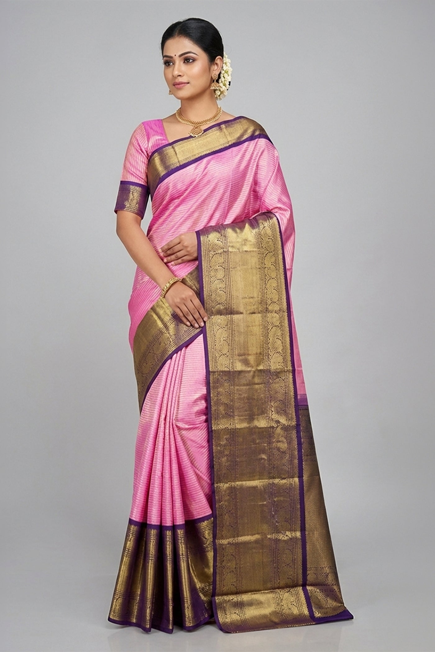 Model wearing a Pure Silk Pure Zari Pink Dual Tone Kanchipuram Saree with Zari Brocade on the body and Zari Border