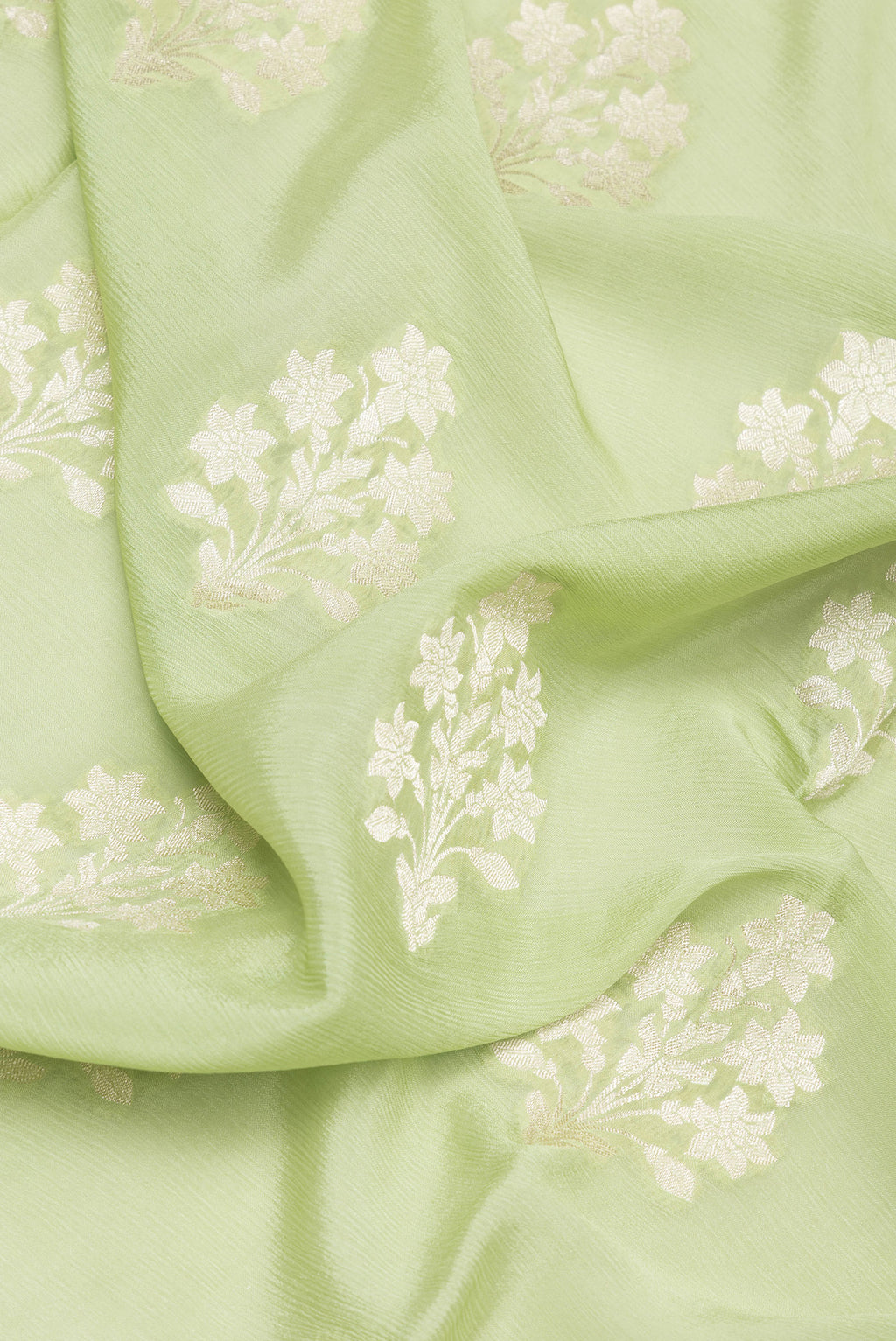 Close up of Pista Green Dual Tone Blended Banarasi Silk Saree with Zari Butta on the body and Zari Border.  displaying folds