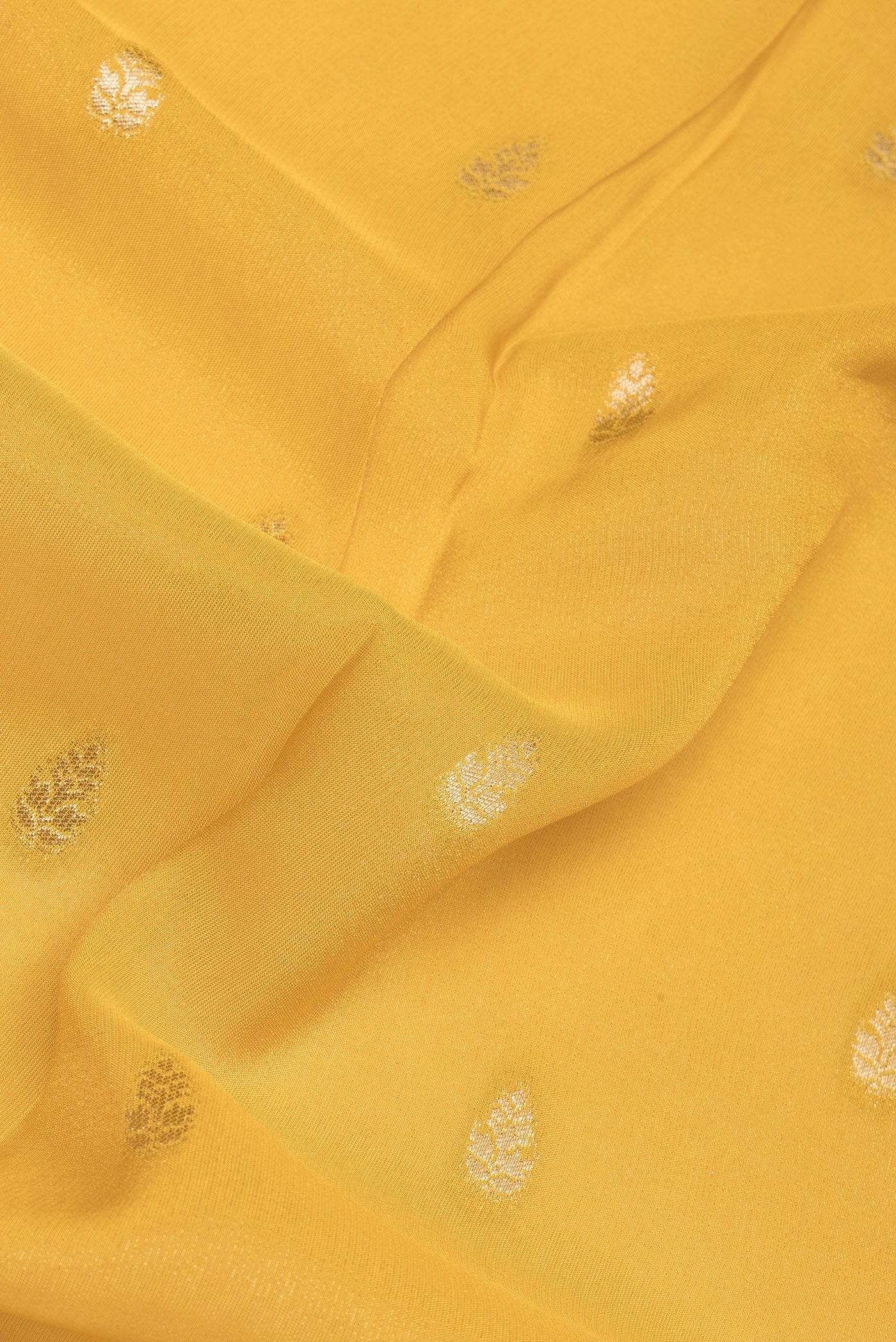 Close up of Mustard Blended Banarasi Silk Saree with Zari Butta on the body and Zari Border.  displaying folds