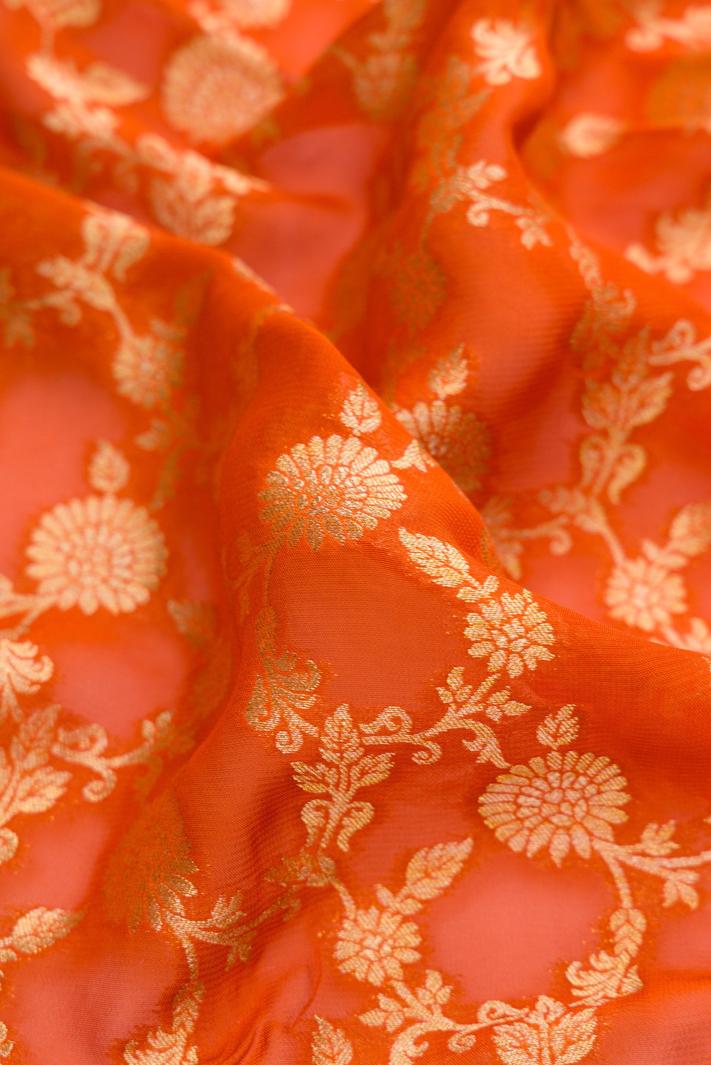 Close up of Brick Orange Blended Banarasi Georgette Saree with Zari Brocade on the body and Zari Border.  displaying folds