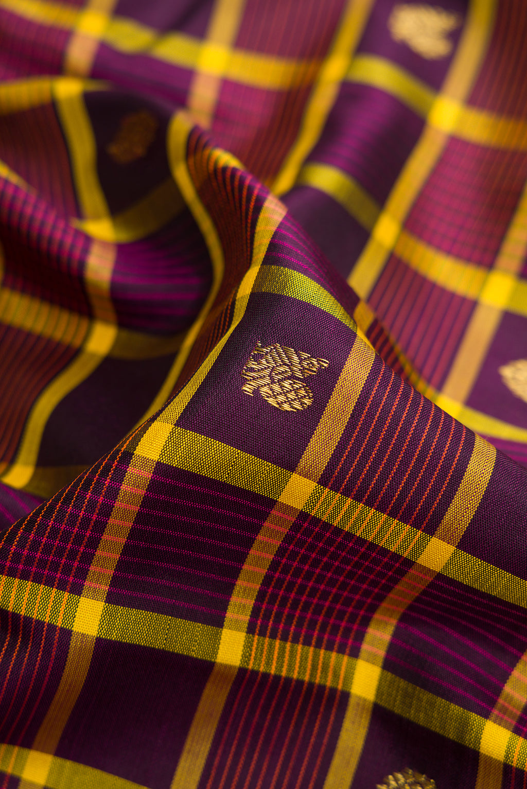 Close up of Pure Silk Pure Zari Burgundy Dual Tone Kanjivaram Saree with Checked design on the body and Zari Border.  displaying folds