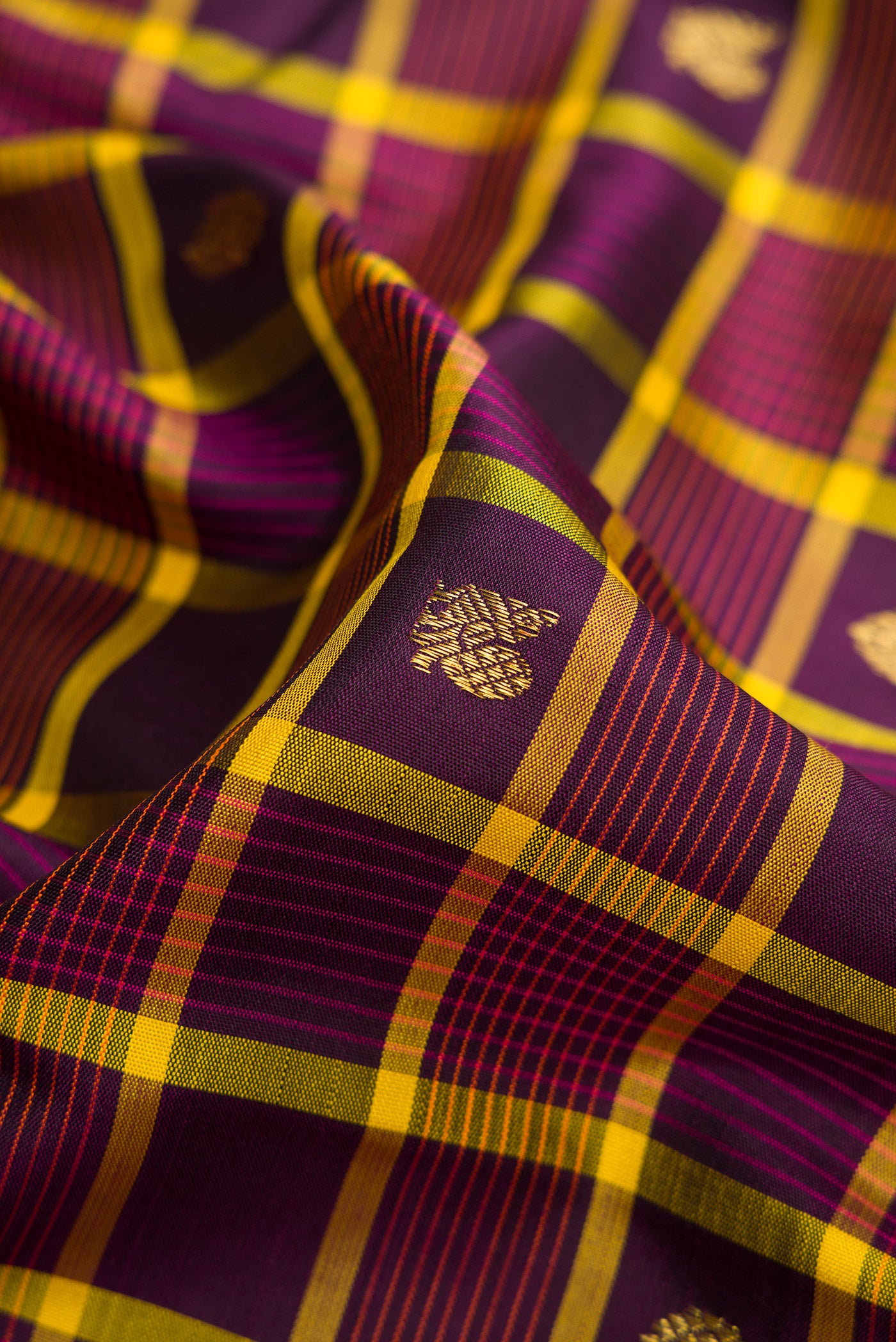 Close up of Pure Silk Pure Zari Burgundy Dual Tone Kanjivaram Saree with Checked design on the body and Zari Border.  displaying folds
