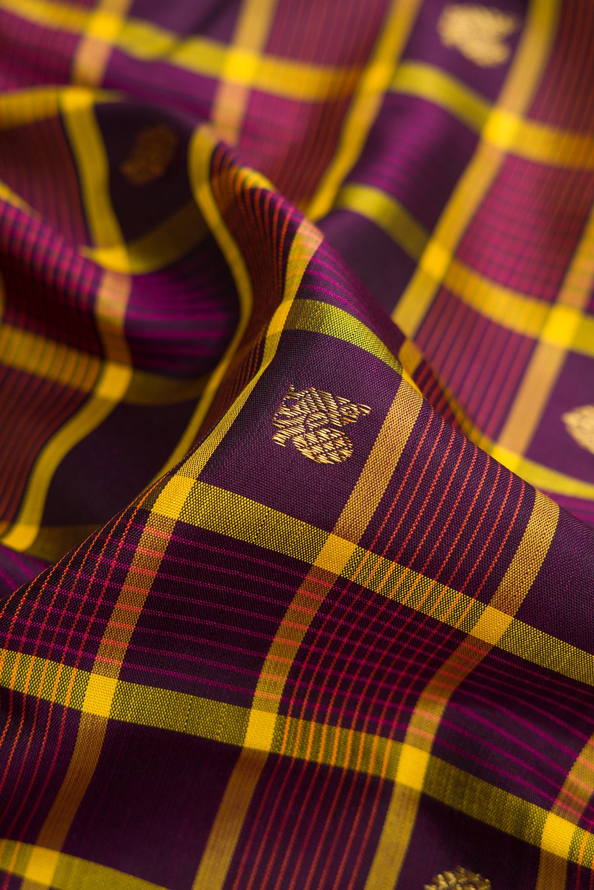 Close up of Pure Silk Pure Zari Burgundy Dual Tone Kanjivaram Saree with Checked design on the body and Zari Border.  displaying folds