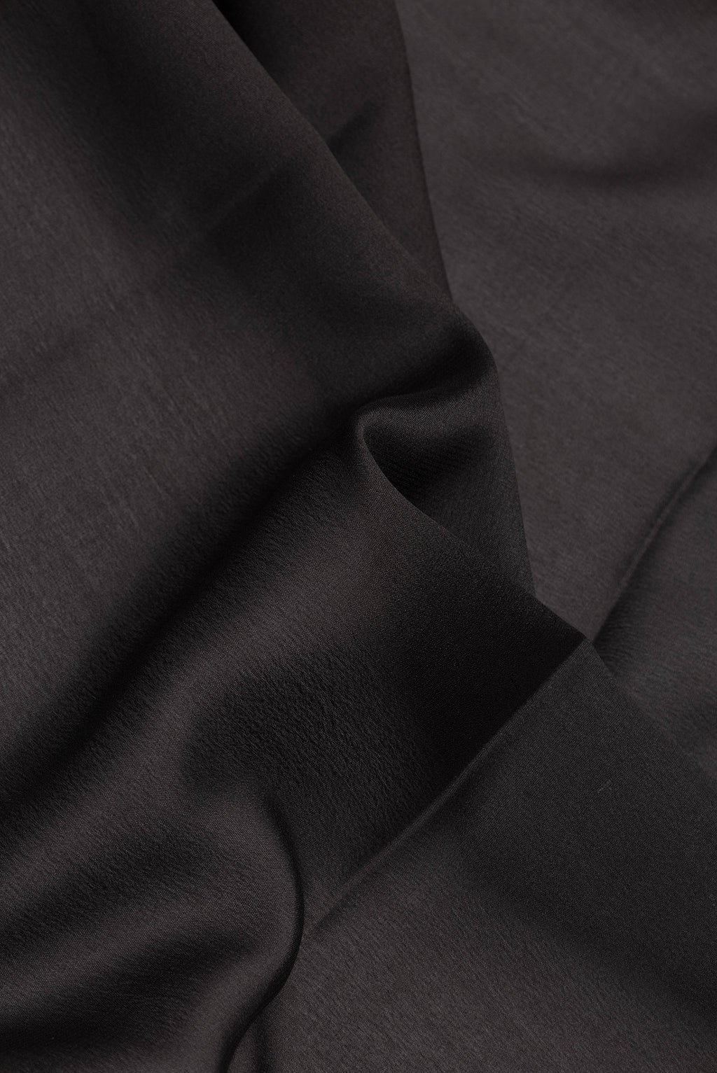 Close up of Black Dual Tone Mysore Silk Saree with Plain Body and Zari Border.  displaying folds