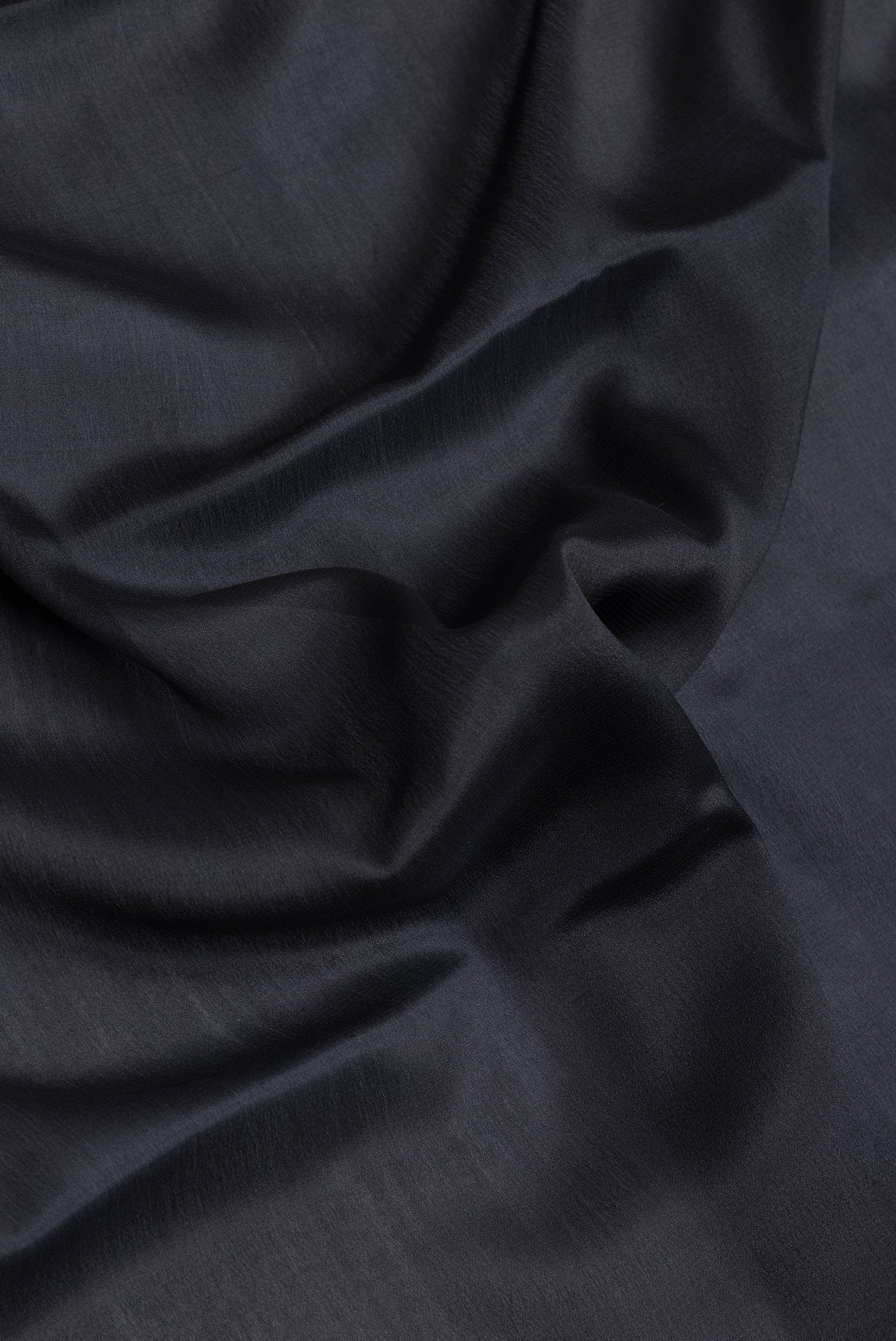 Close up of Black Dual Tone Mysore Silk Saree with Plain Body and Zari Border.  displaying folds