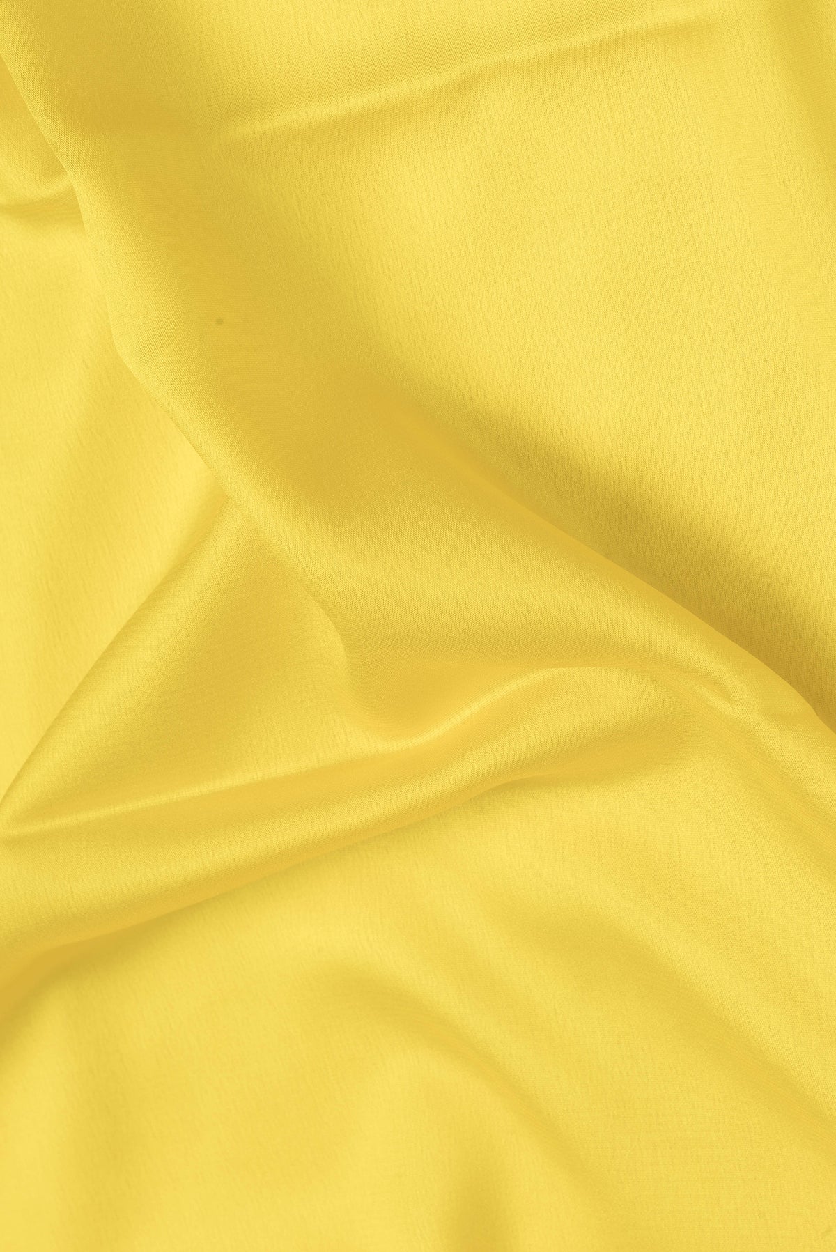 Close up of Yellow Dual Tone Mysore Crepe Saree with Plain Body and Zari Border.  displaying folds