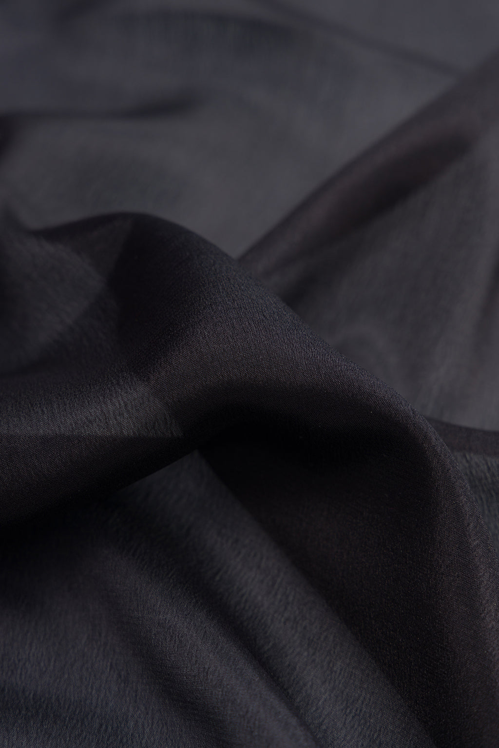 Close up of Black Mysore Crepe Saree with Plain Body and Zari Border.  displaying folds