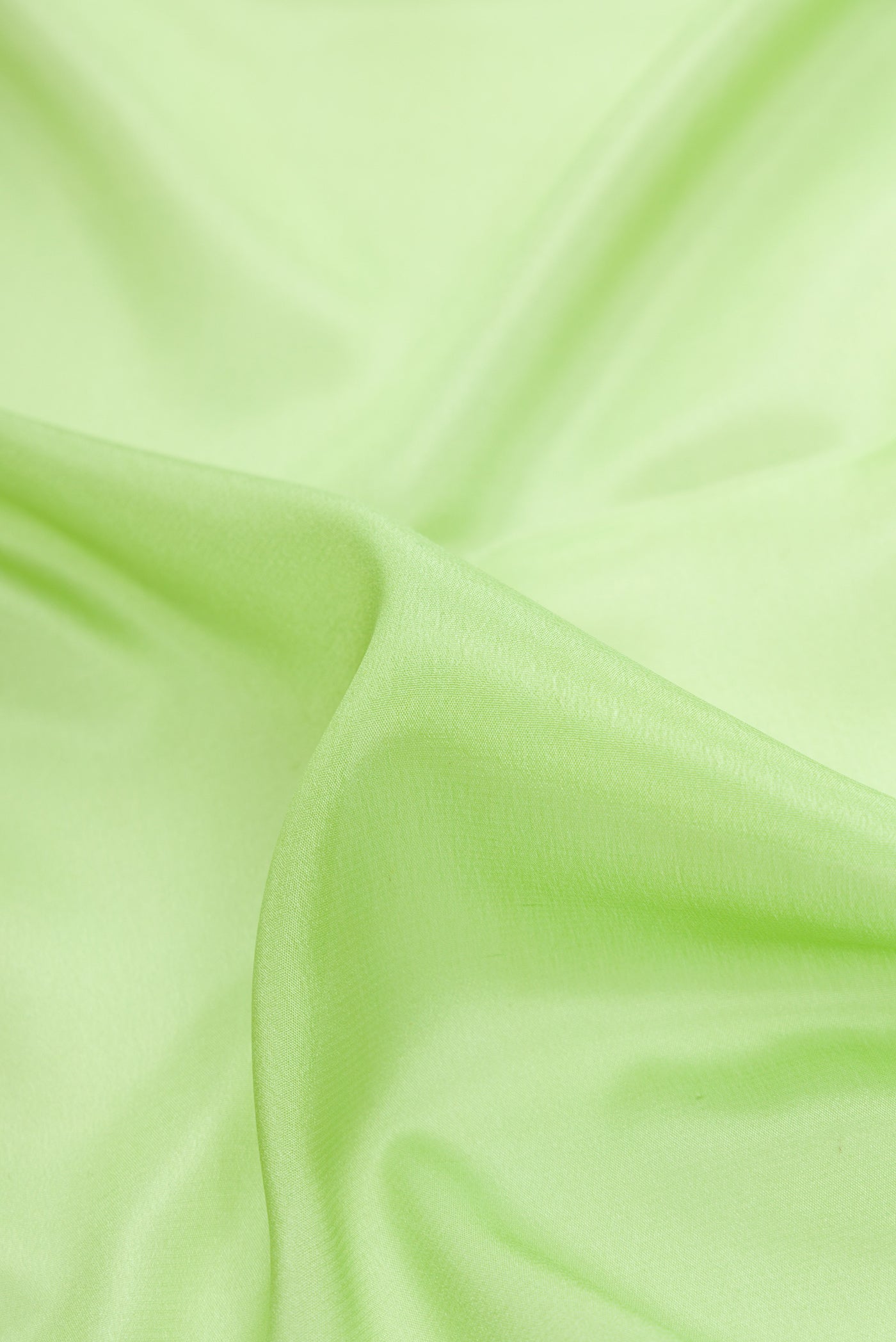 Close up of Pista Green Dual Tone Mysore Crepe Saree with Plain Body and Zari Border.  displaying folds