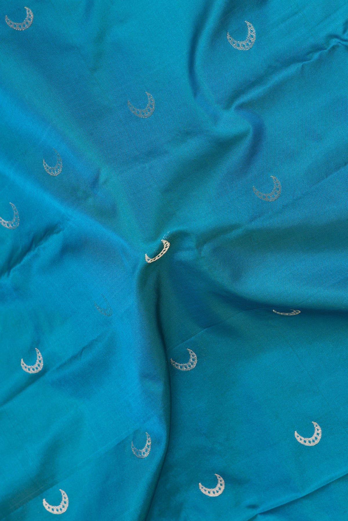 Close up of Peacock Blue Blended Paithani Silk Saree with Zari Butta on the body and Zari Border.  displaying folds