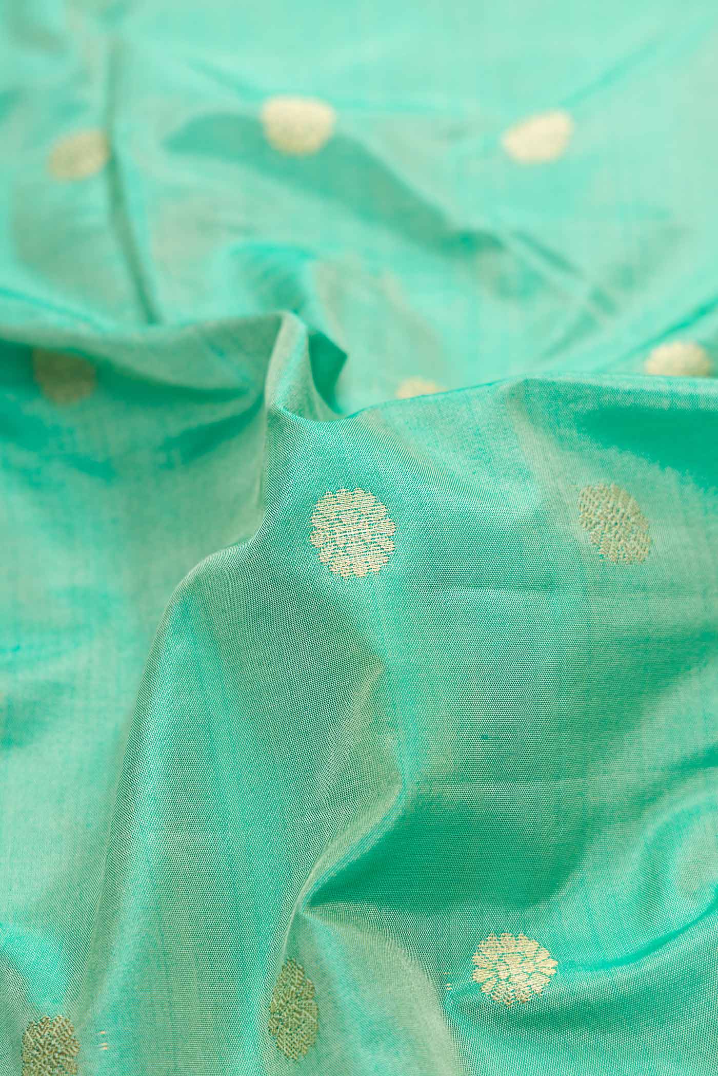 Close up of Sea Green Blended Bangalore Silk Saree with Zari Butta on the body and Zari Border displaying folds