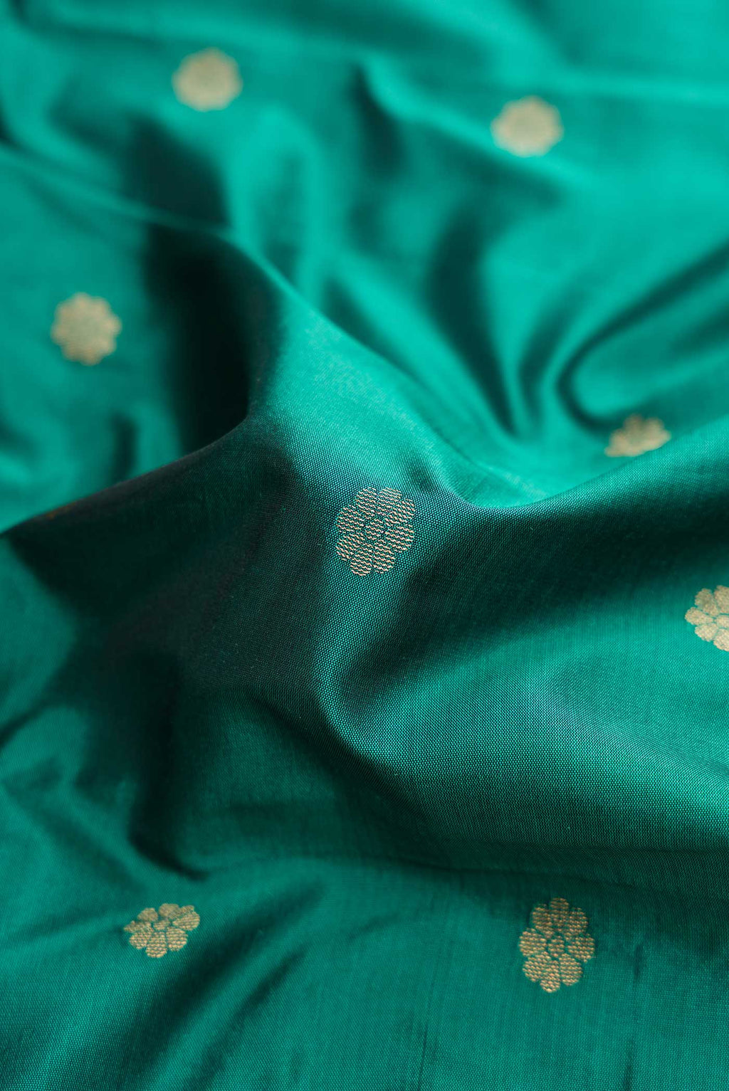 Close up of Teal Blended Bangalore Silk Saree with Zari Butta on the body and Zari Border displaying folds