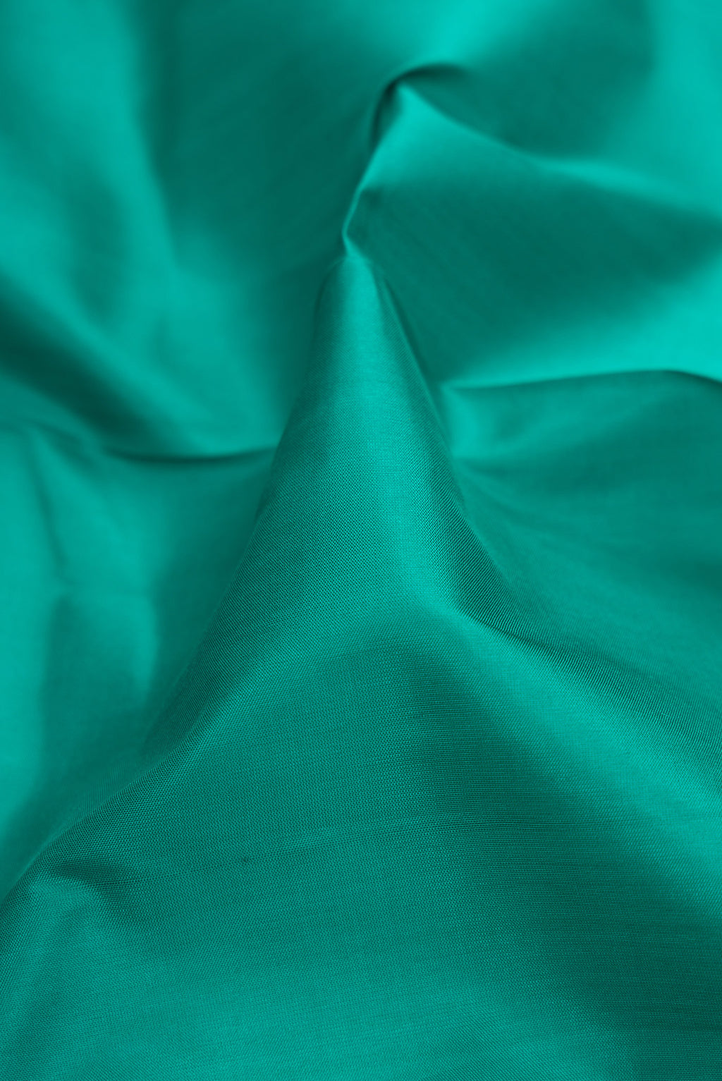 Close up of Sea Green Dual Tone Soft Silk Saree with Plain Body and Fancy Border.  displaying folds