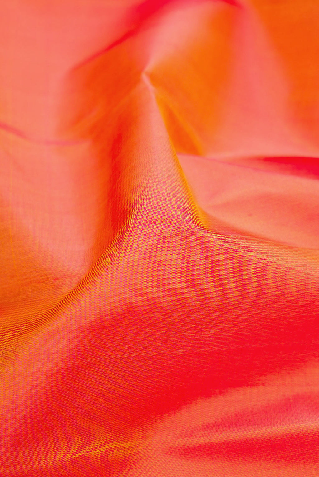 Close up of Orange Dual Tone Soft Silk Saree with Plain Body and Fancy Border.  displaying folds