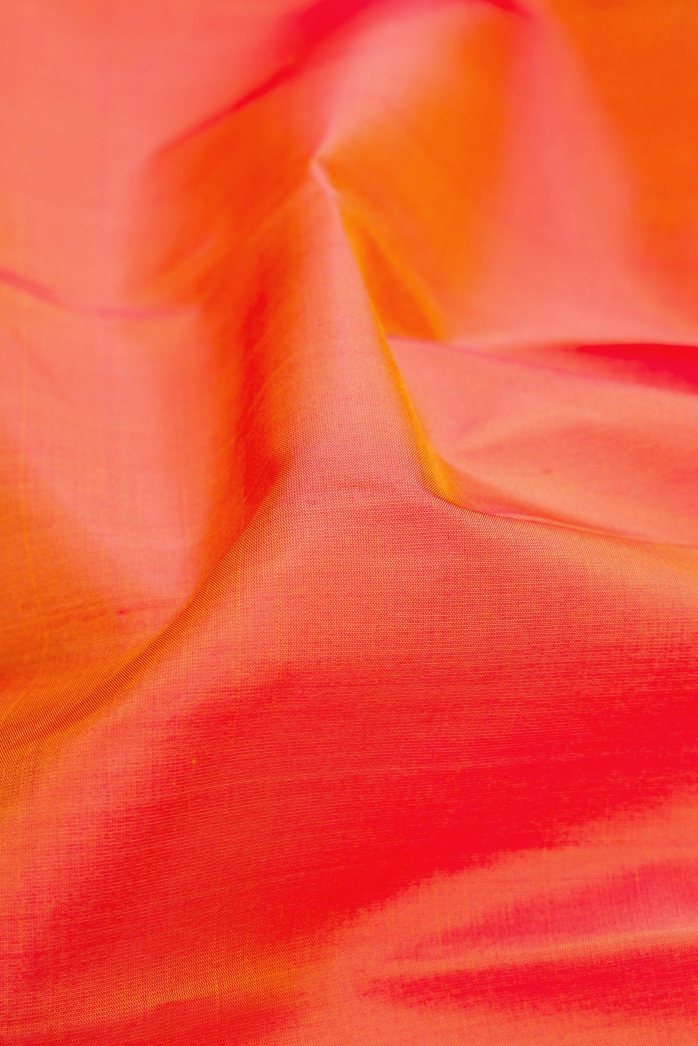 Close up of Orange Dual Tone Soft Silk Saree with Plain Body and Fancy Border.  displaying folds
