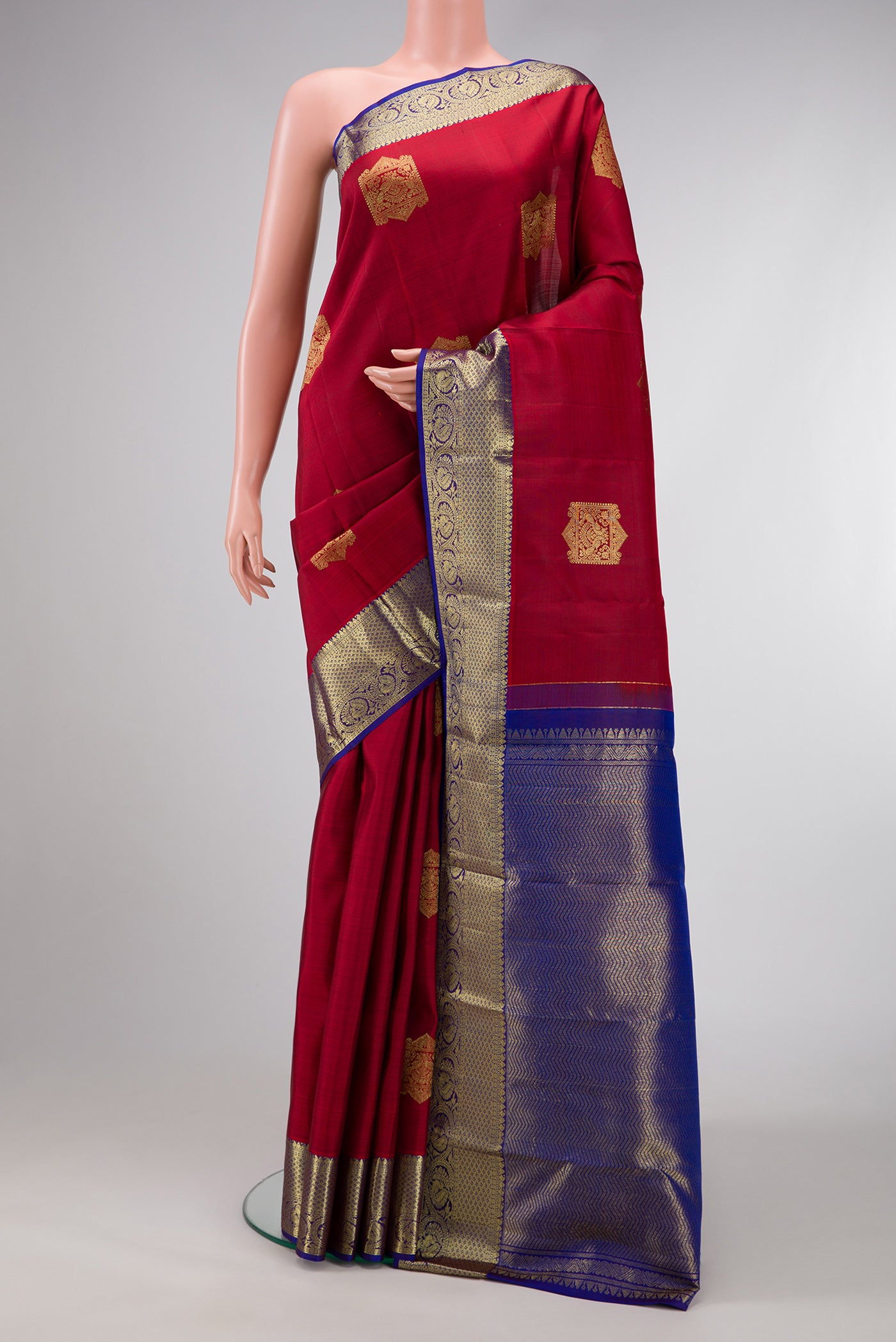 Maroon Dual Tone Kanjivaram Silk Saree with Zari Butta on the body and Zari Border.  displayed on a mannequin