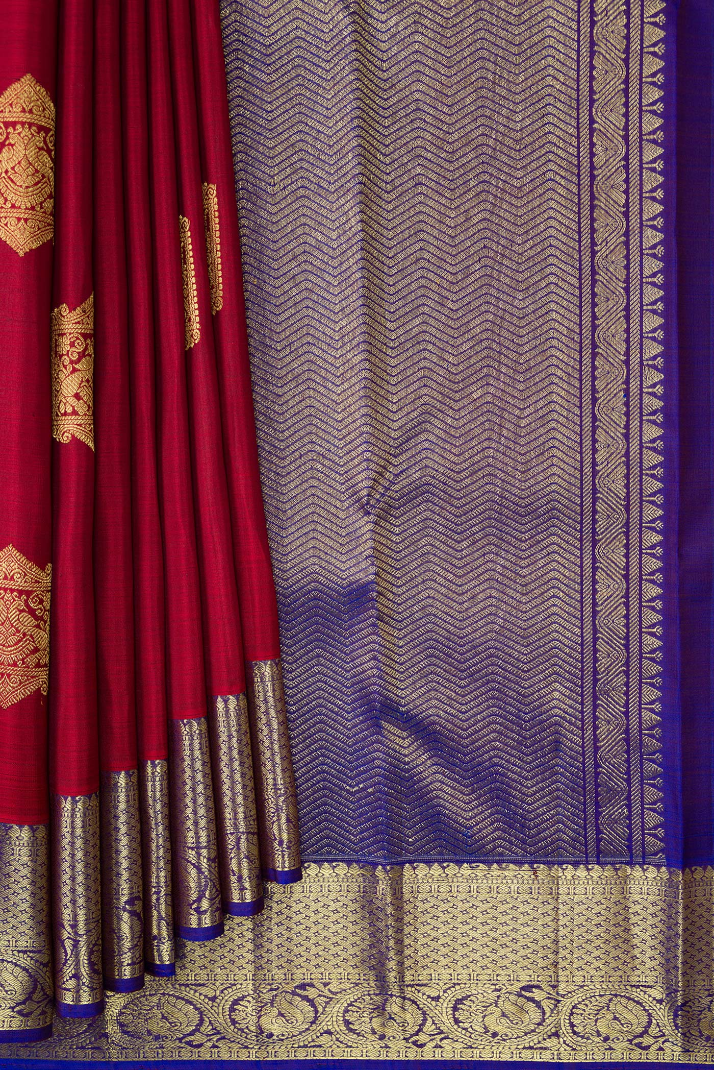 Pleats and pallu of Maroon Dual Tone Kanjivaram Silk Saree with Zari Butta on the body and Zari Border. 