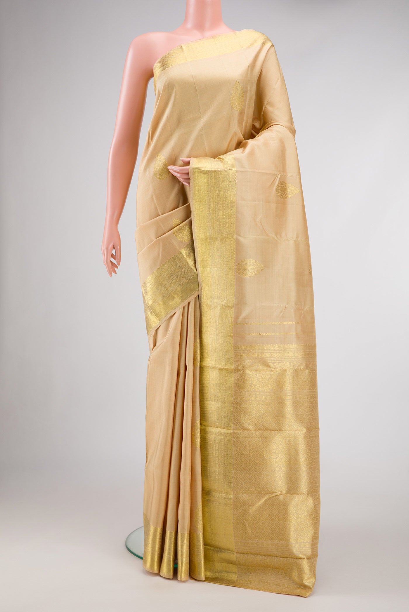 Beige Dual Tone Kanjivaram Silk Saree with Zari Butta on the body and Zari Border.  displayed on a mannequin