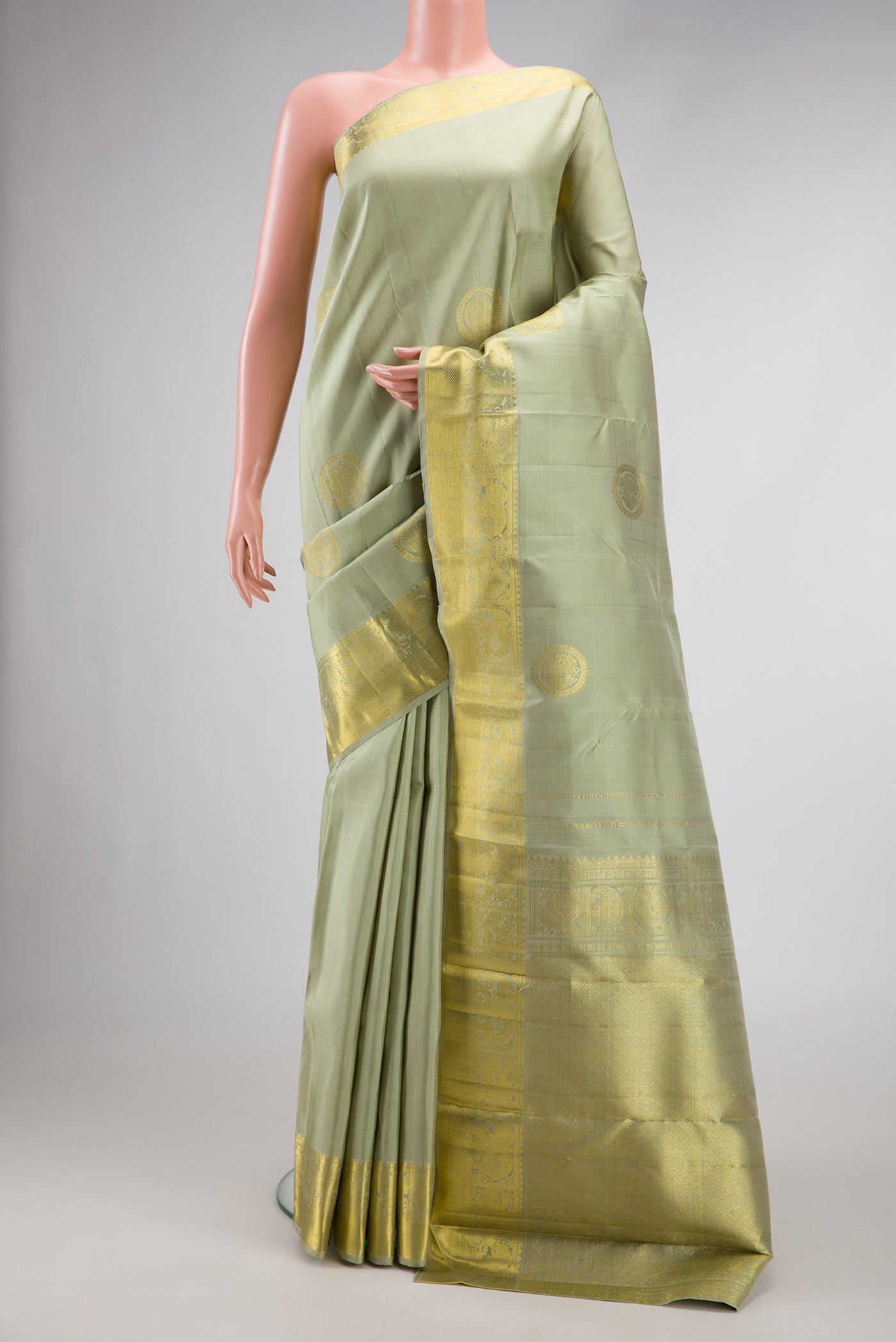 Pista Green Dual Tone Kanjivaram Silk Saree with Zari Butta on the body and Zari Border.  displayed on a mannequin