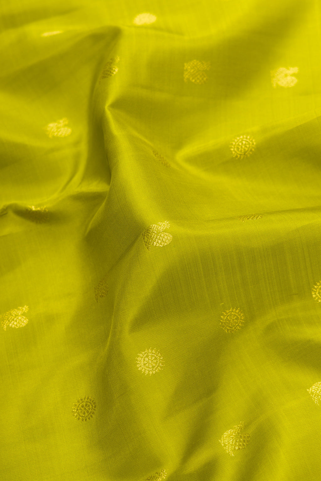 Close up of Parrot Green Dual Tone Kanjivaram Silk Saree with Zari Butta on the body and Zari Border.  displaying folds