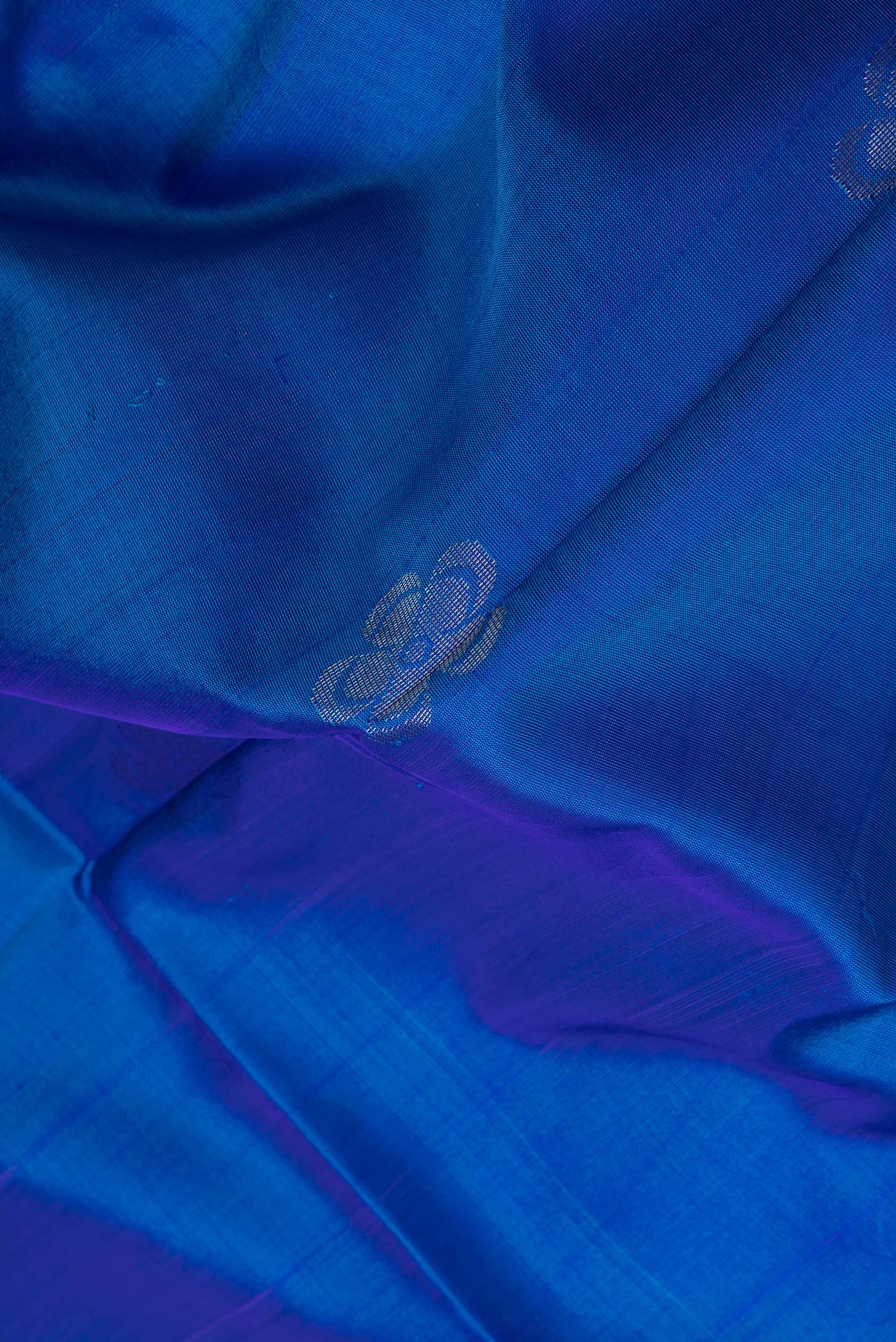 Close up of Peacock Blue Dual Tone Uppada Silk Saree with Zari Butta on the body and Zari Border.  displaying folds