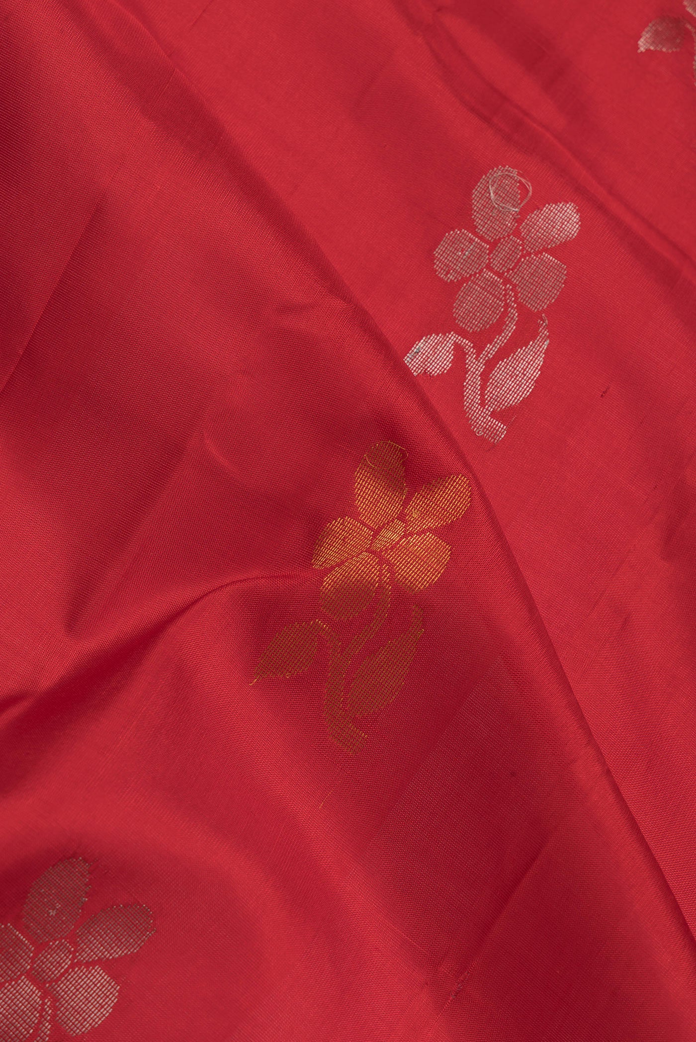 Close up of Red Dual Tone Uppada Silk Saree with Zari Butta on the body and Fancy Border.  displaying folds