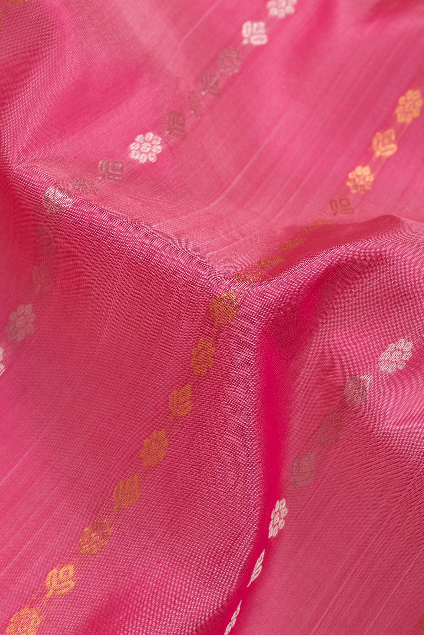 Close up of Pink Dual Tone Uppada Silk Saree with Zari Butta on the body and Zari Border.  displaying folds