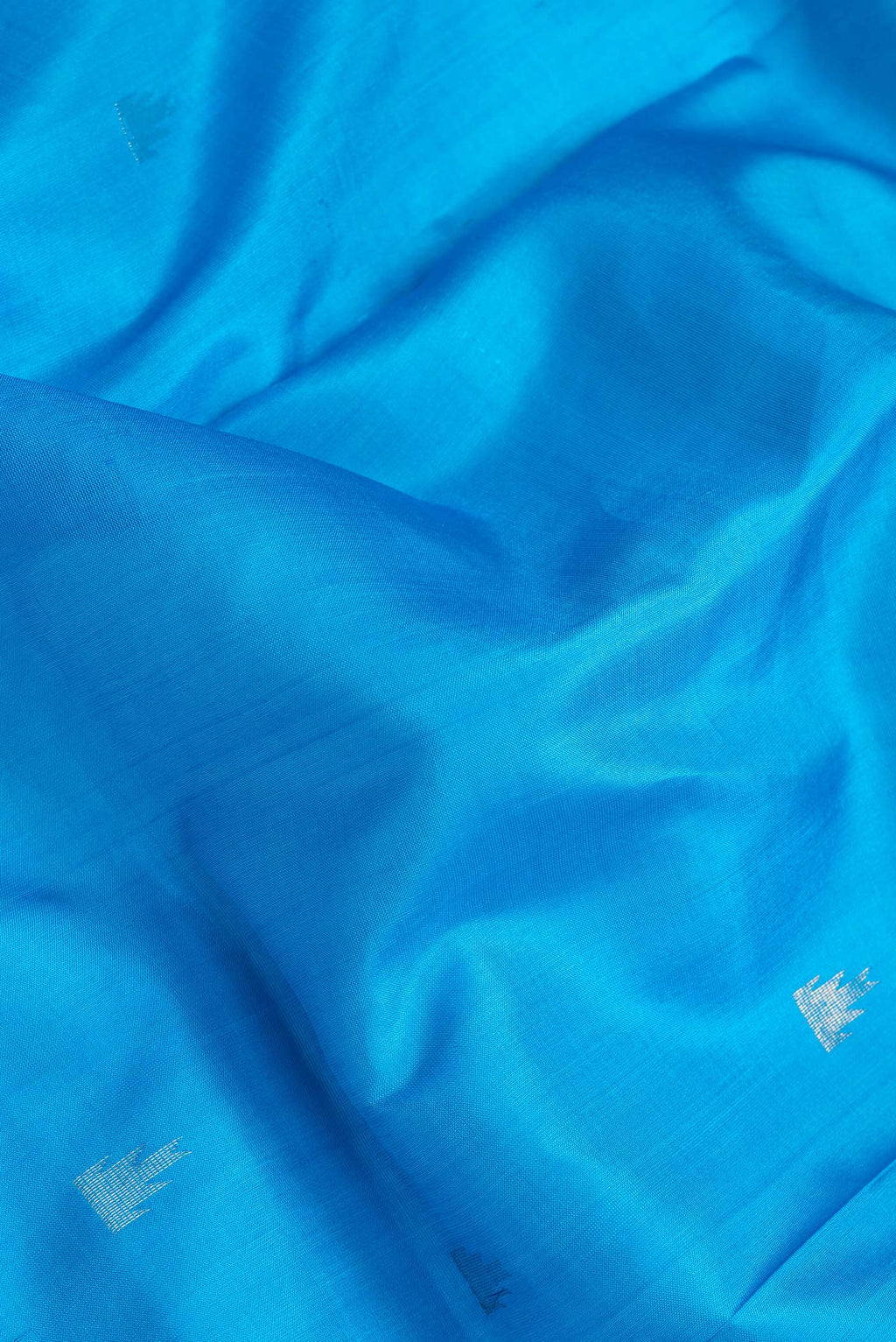 Close up of Sky Blue Dual Tone Uppada Silk Saree with Zari Butta on the body and Temple Border.  displaying folds