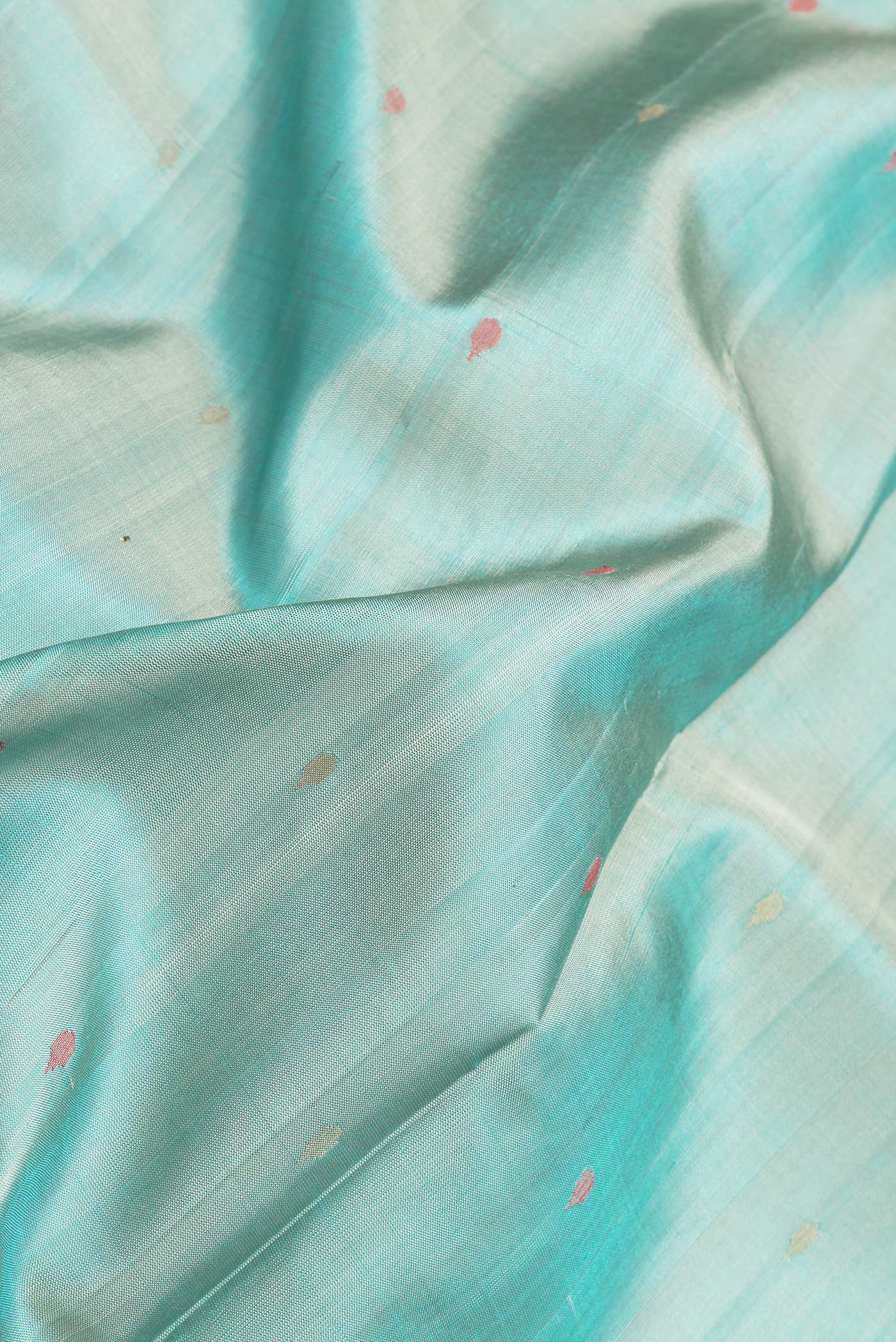 Close up of Sea Green Dual Tone Uppada Silk Saree with Zari And Thread Butta on the body and Zari Border.  displaying folds