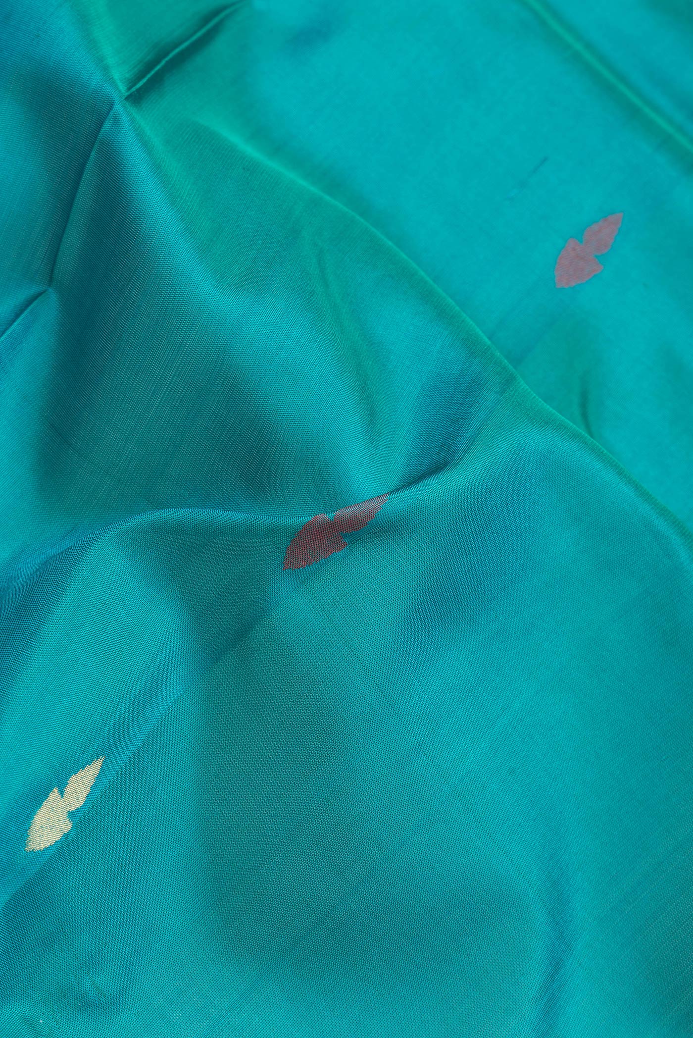Close up of Sky Blue Dual Tone Uppada Silk Saree with Zari And Thread Butta on the body and Zari Border.  displaying folds