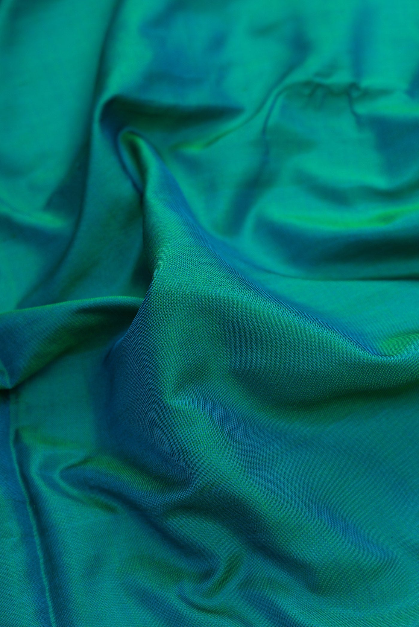 Close up of Peacock Blue Dual Tone Uppada Silk Saree with Plain Body and Zari Border.  displaying folds