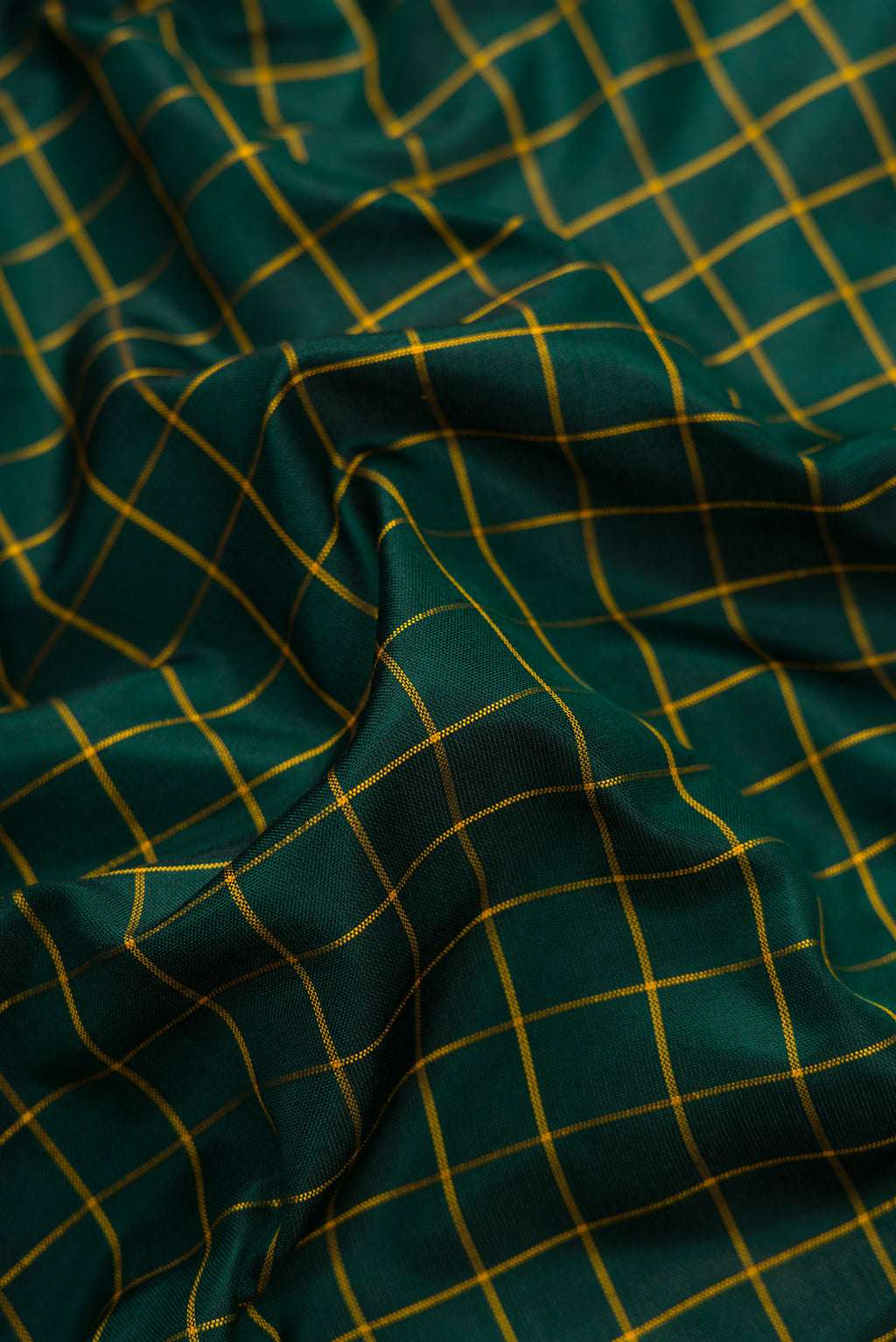 Close up of Green Dual Tone Soft Silk Saree with Zari Butta on the body and Zari Border.  displaying folds