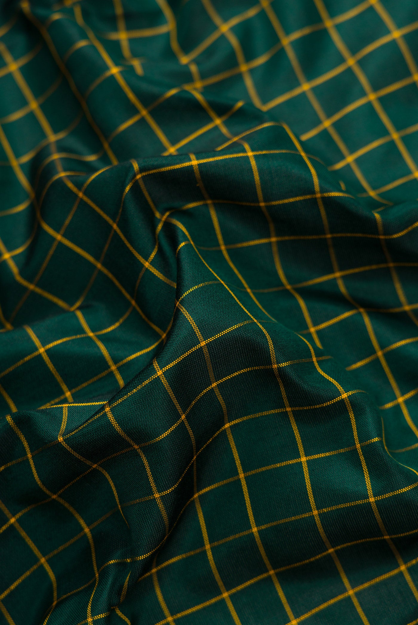 Close up of Green Dual Tone Soft Silk Saree with Zari Butta on the body and Zari Border.  displaying folds