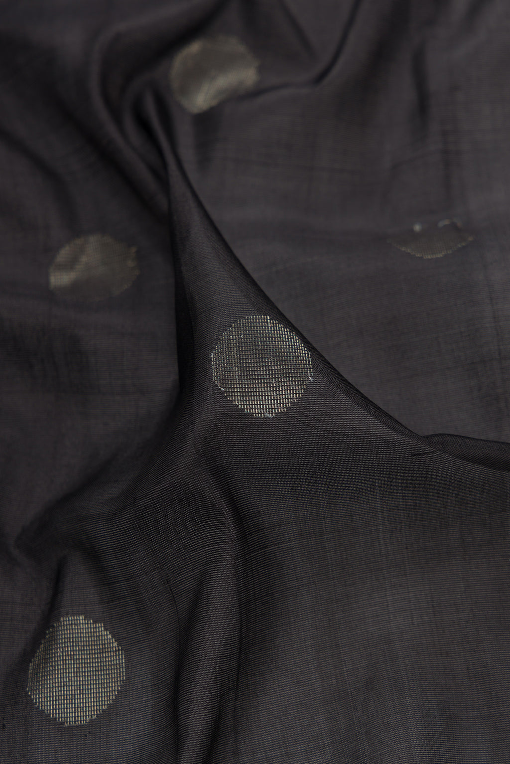 Close up of Black Dual Tone Uppada Silk Saree with Zari Butta on the body and Zari Border.  displaying folds