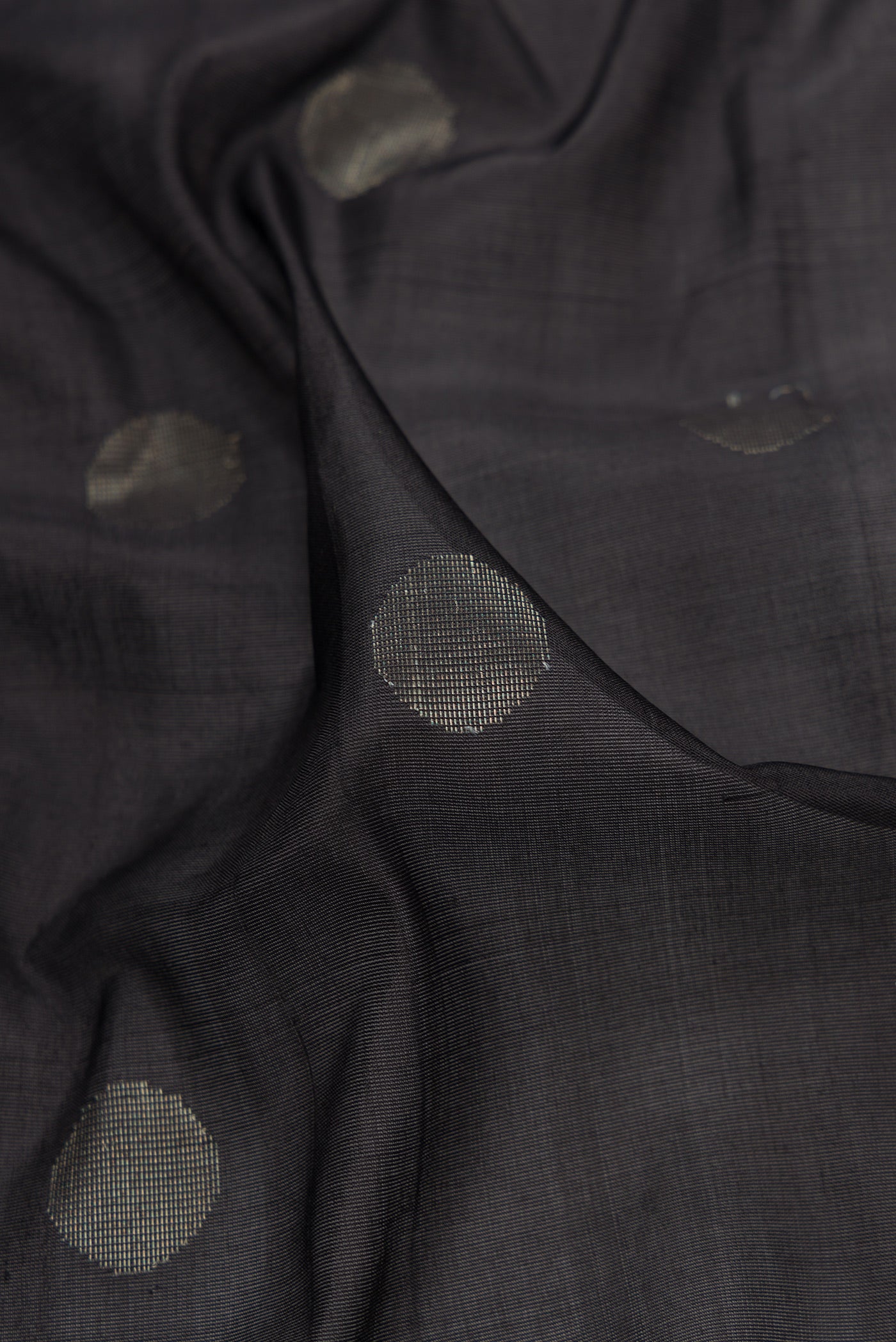Close up of Black Dual Tone Uppada Silk Saree with Zari Butta on the body and Zari Border.  displaying folds
