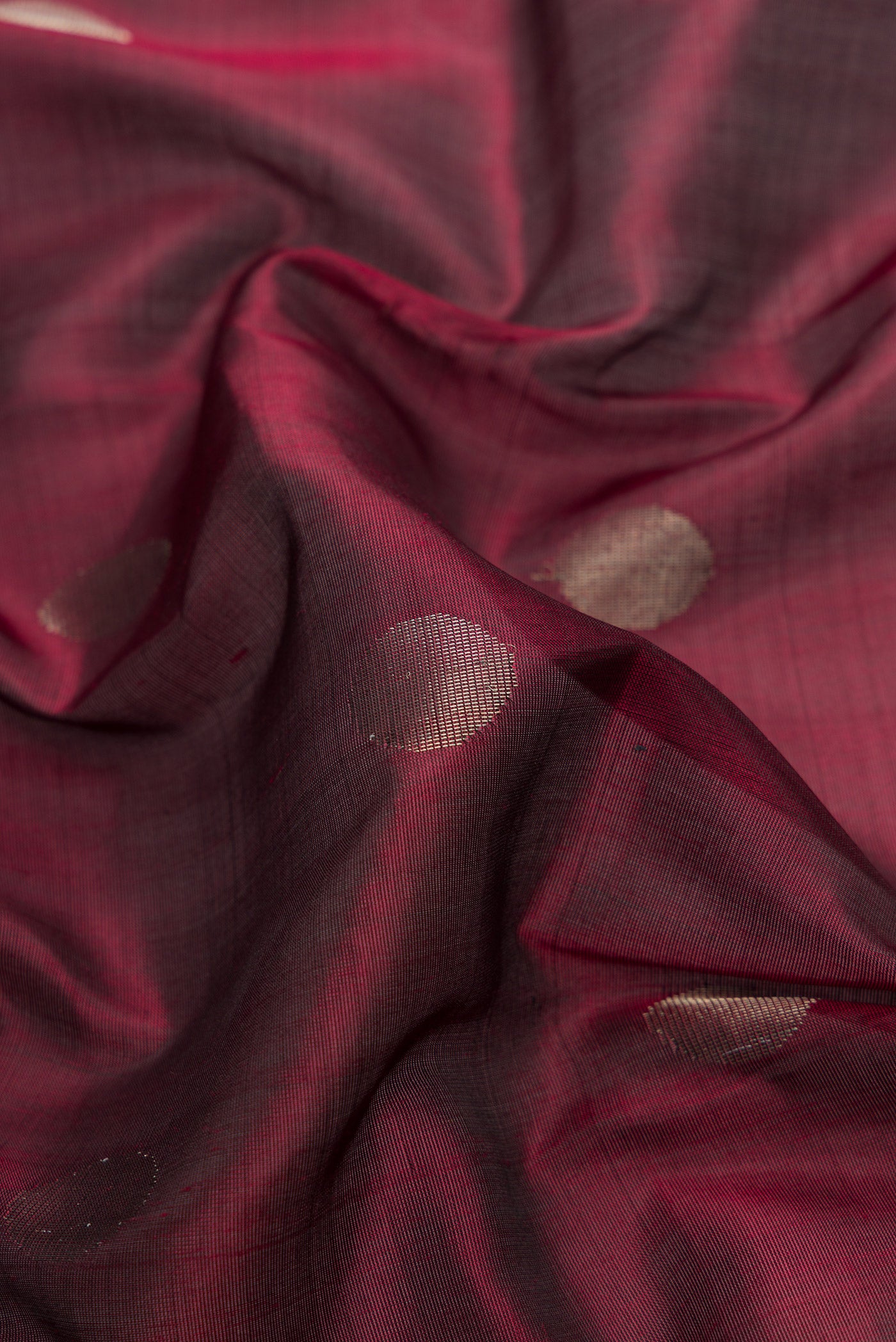 Close up of Maroon Dual Tone Uppada Silk Saree with Zari Butta on the body and Zari Border.  displaying folds